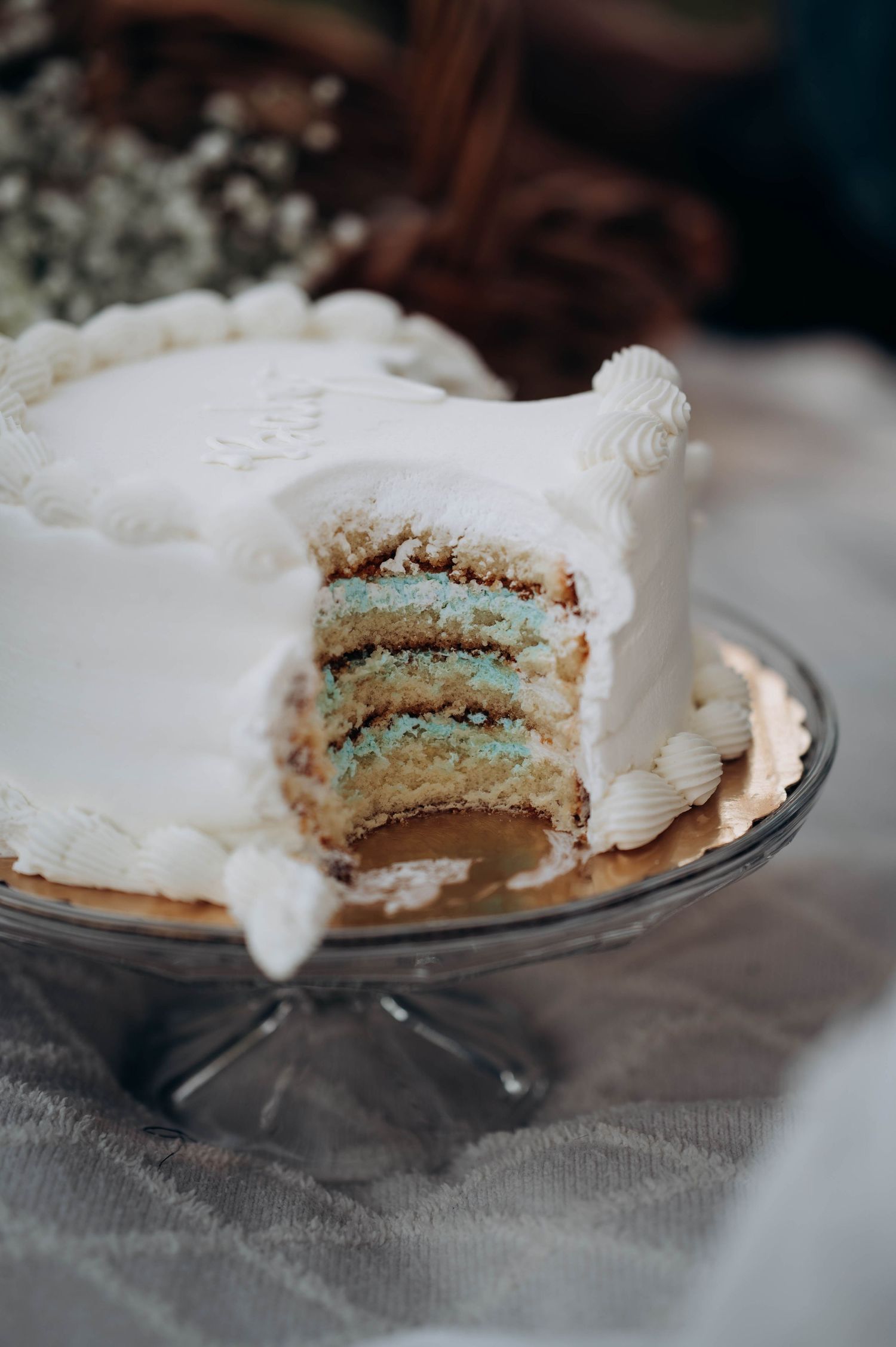 Close-up of sliced gender reveal cake showing blue layers inside.