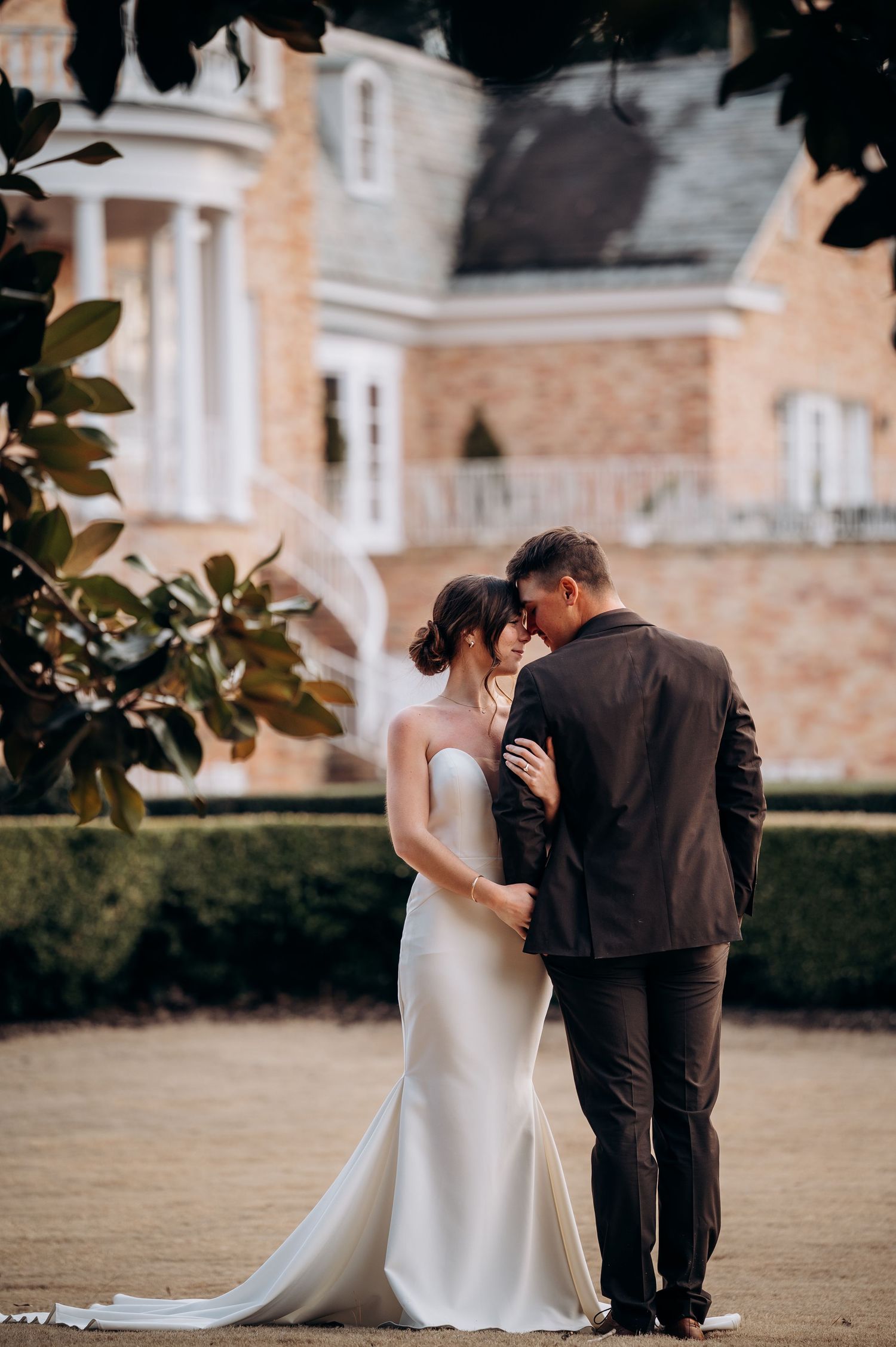 Wedding couple shares romantic moment on grounds of historic stone building.