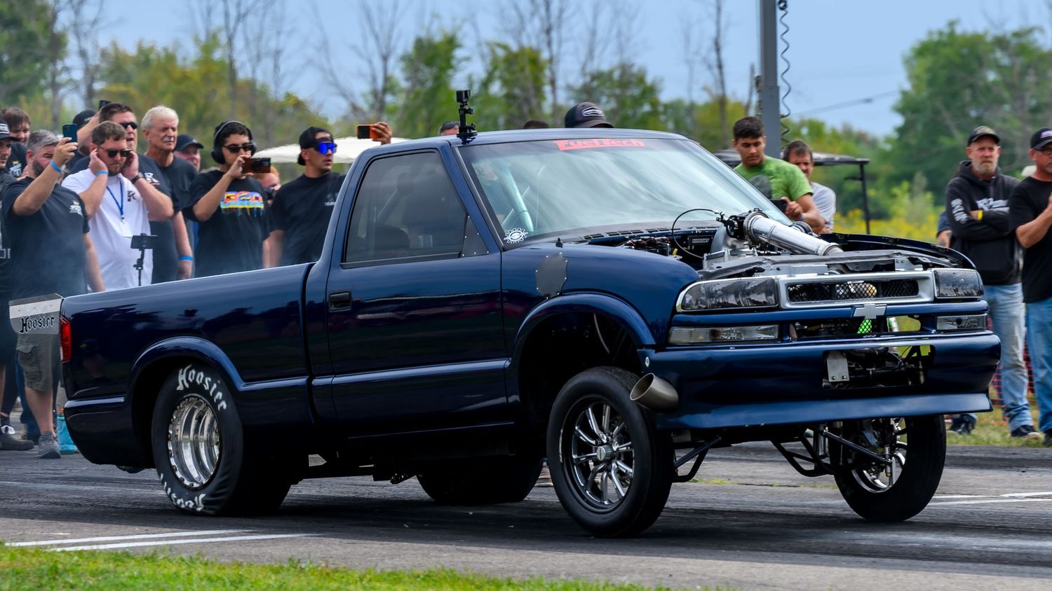 Modified racing vehicles competing at a professional drag strip event.