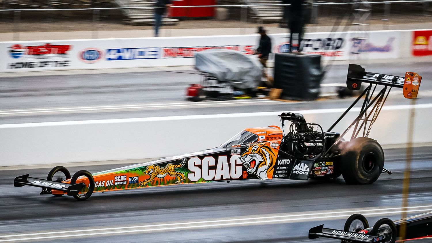 Professional drag racing cars competing at high speeds on a race track.