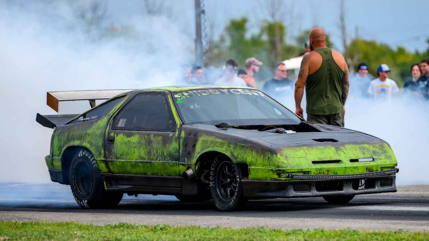 Drag racing cars creating smoke clouds during competition runs.