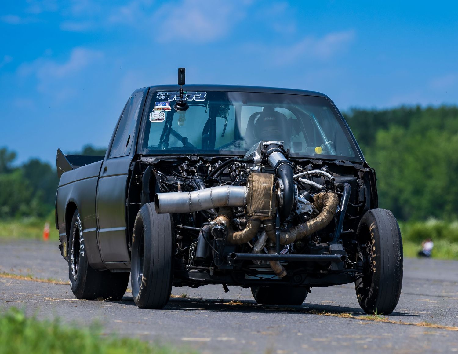 Low-angle view of modified cars with exposed engines and custom bodywork.