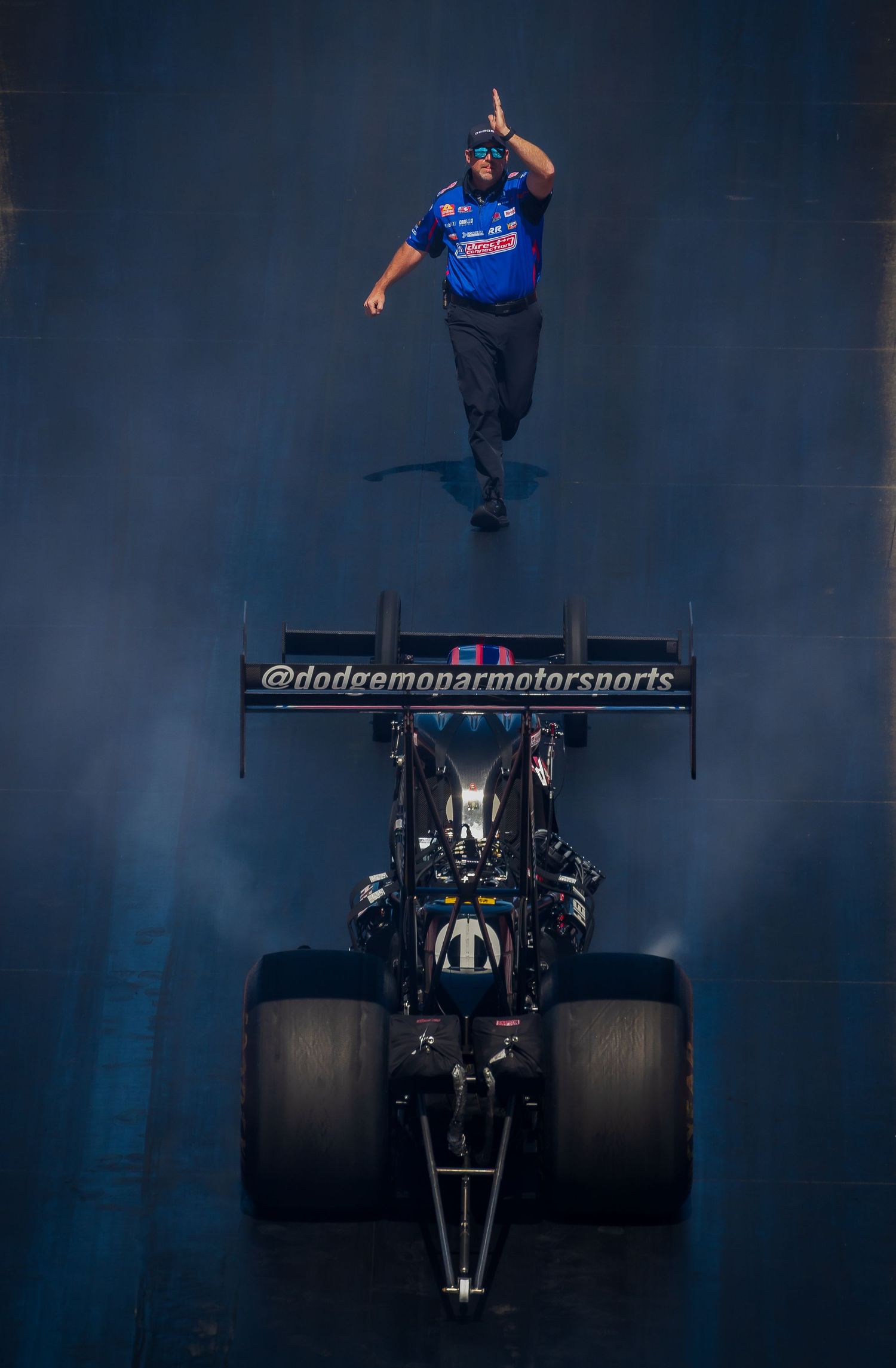 Top-down view of a black racing vehicle with prominent rear wing and large racing tires.