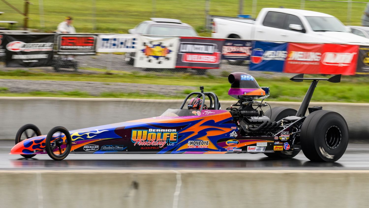 Formula racing cars speed around a racetrack during a competitive motorsport event.