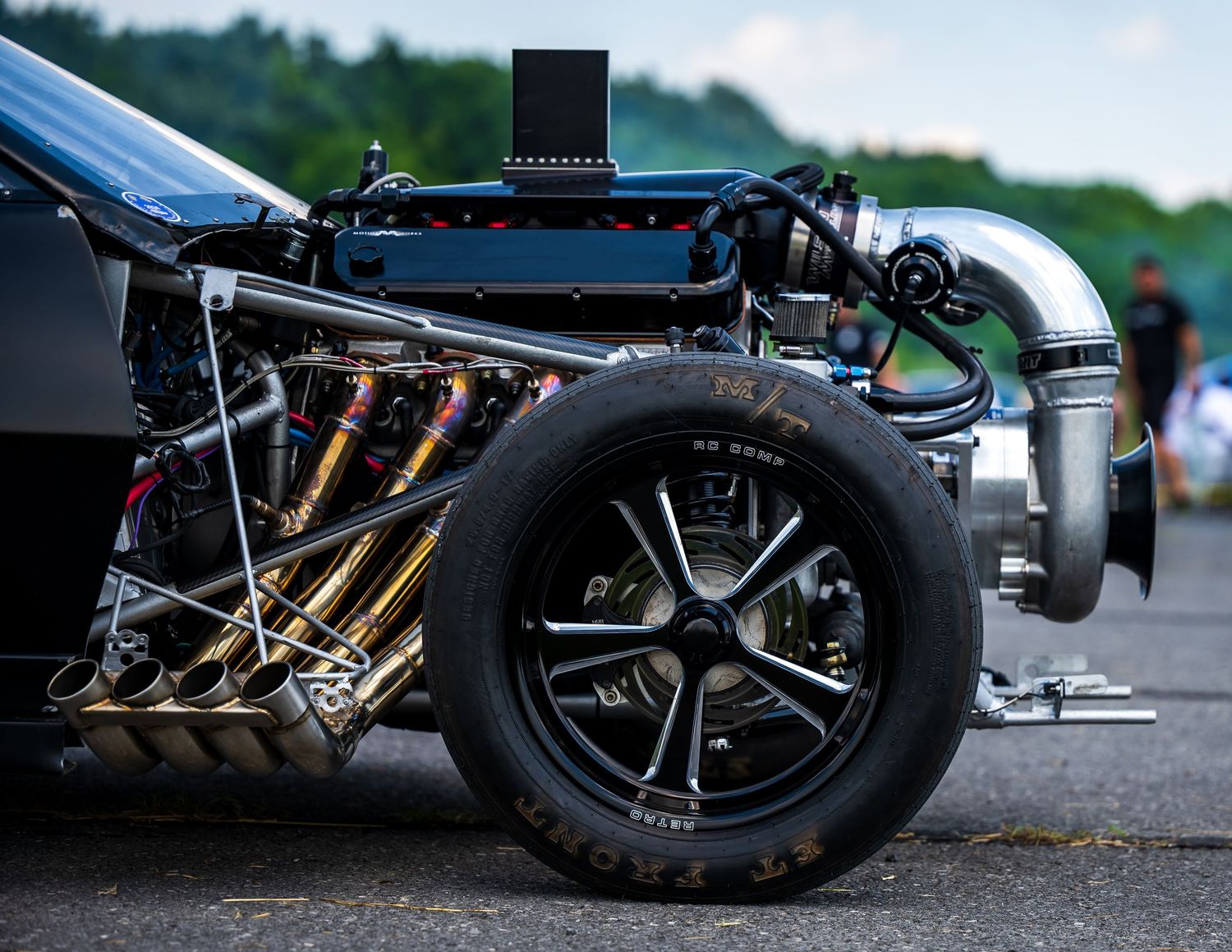 Close-up details of custom car wheels and suspension components at ground level.