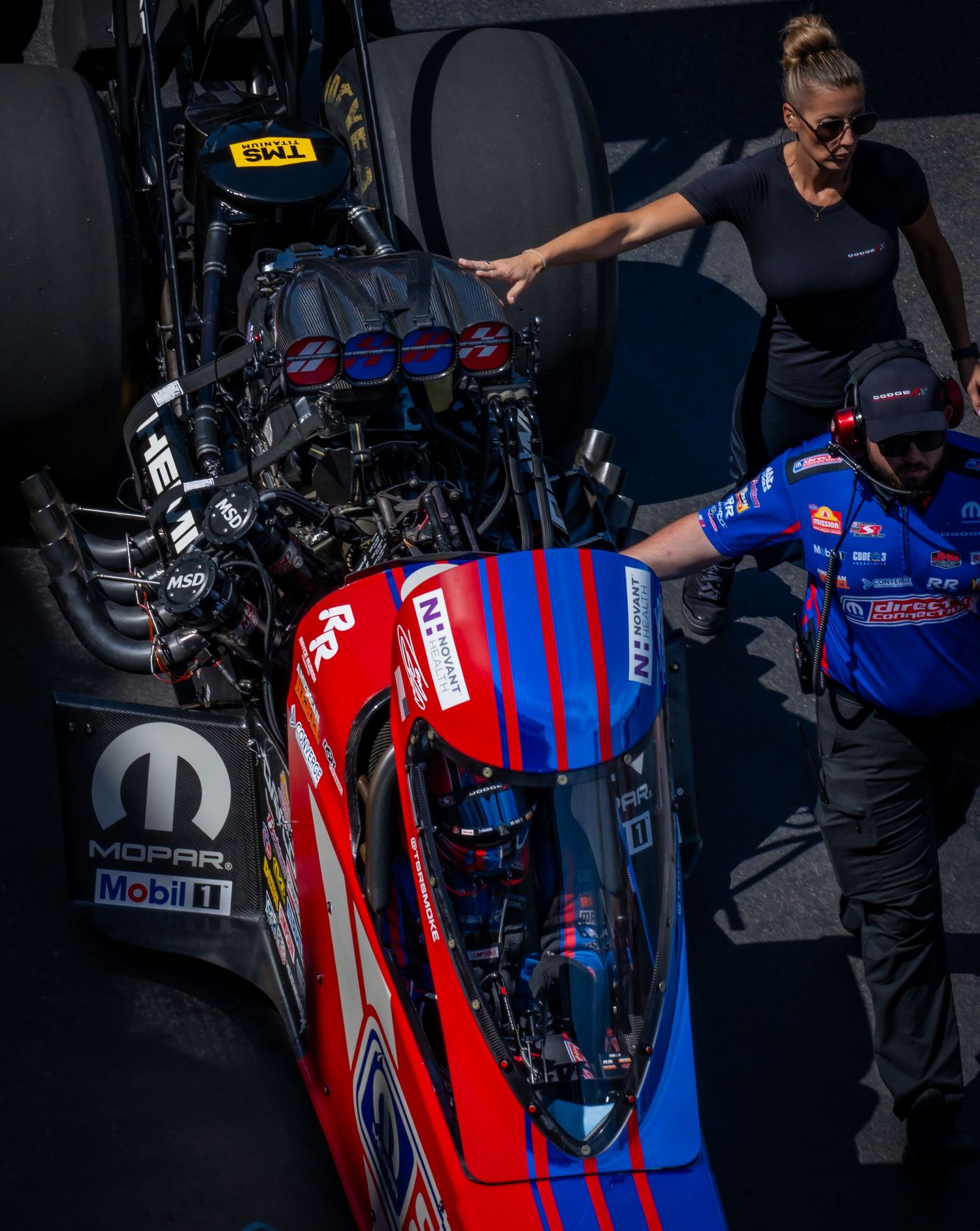 Close-up details of a red and blue racing vehicle with sponsor decals and technical components.