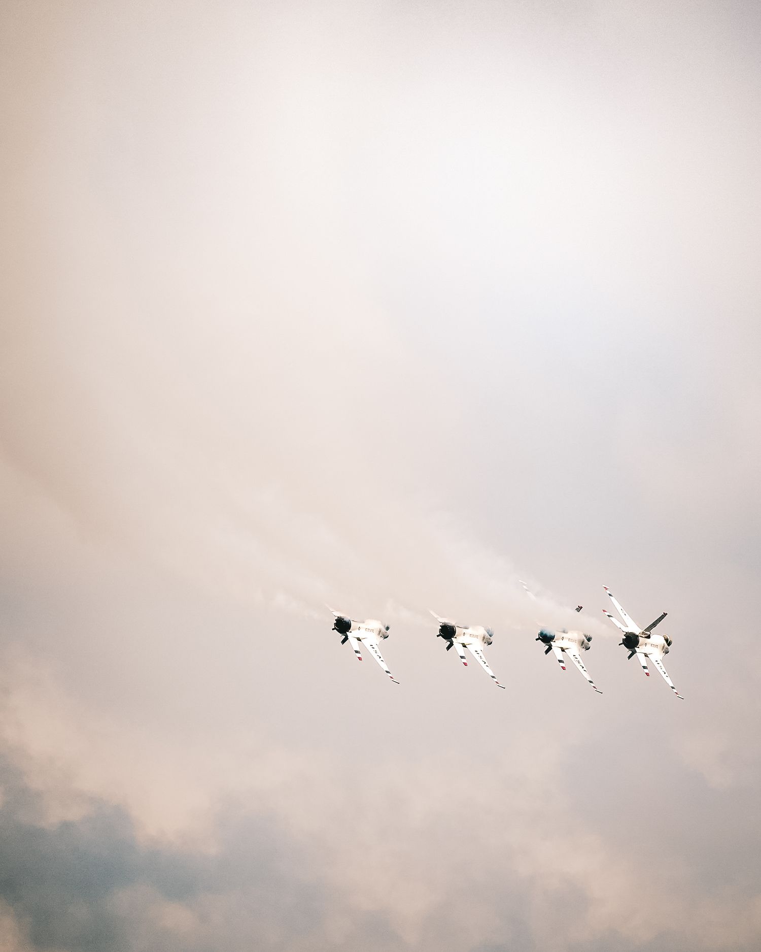 Formation of aircraft flying in cloudy sky conditions.