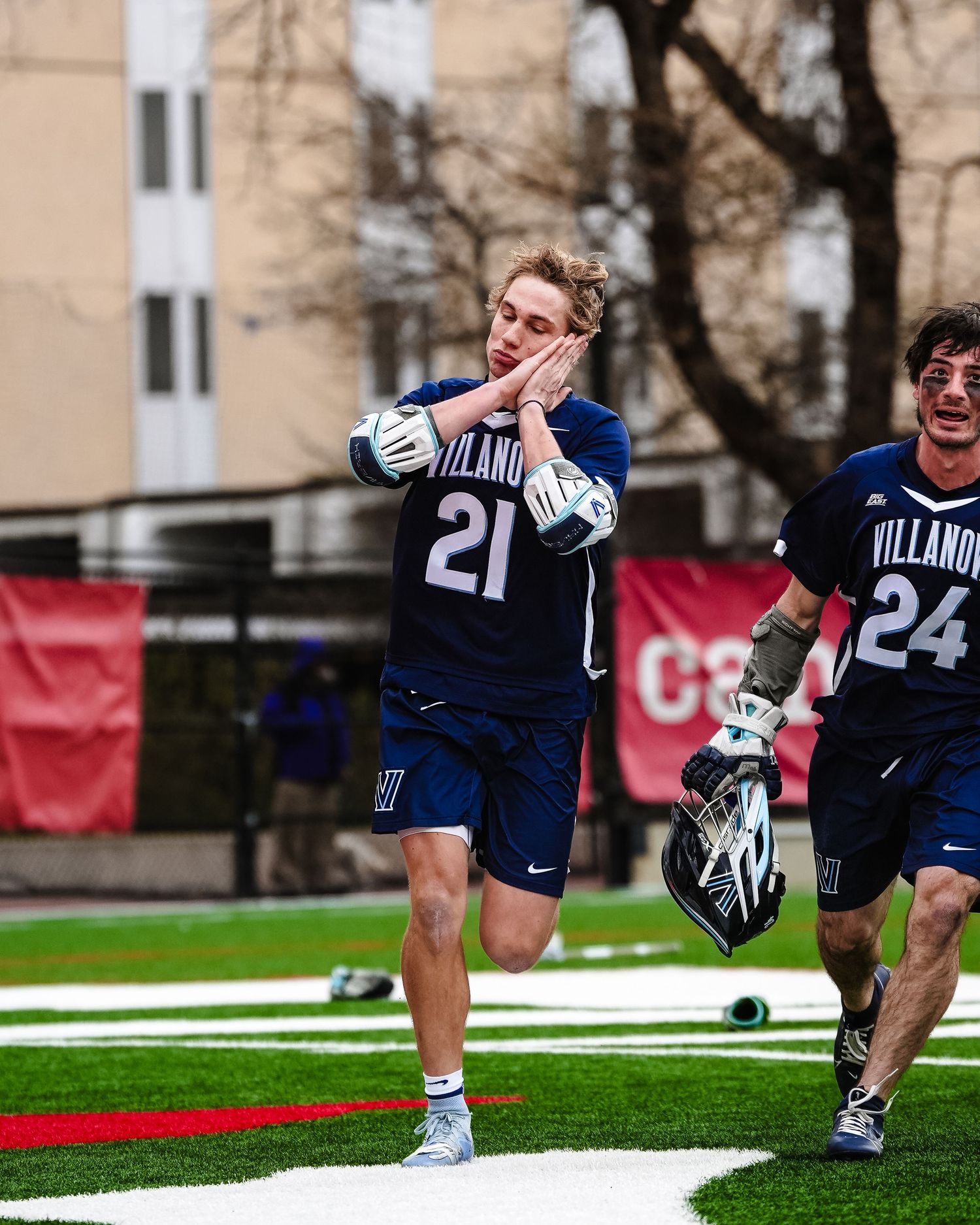 Two Villanova lacrosse players celebrating on field during game.