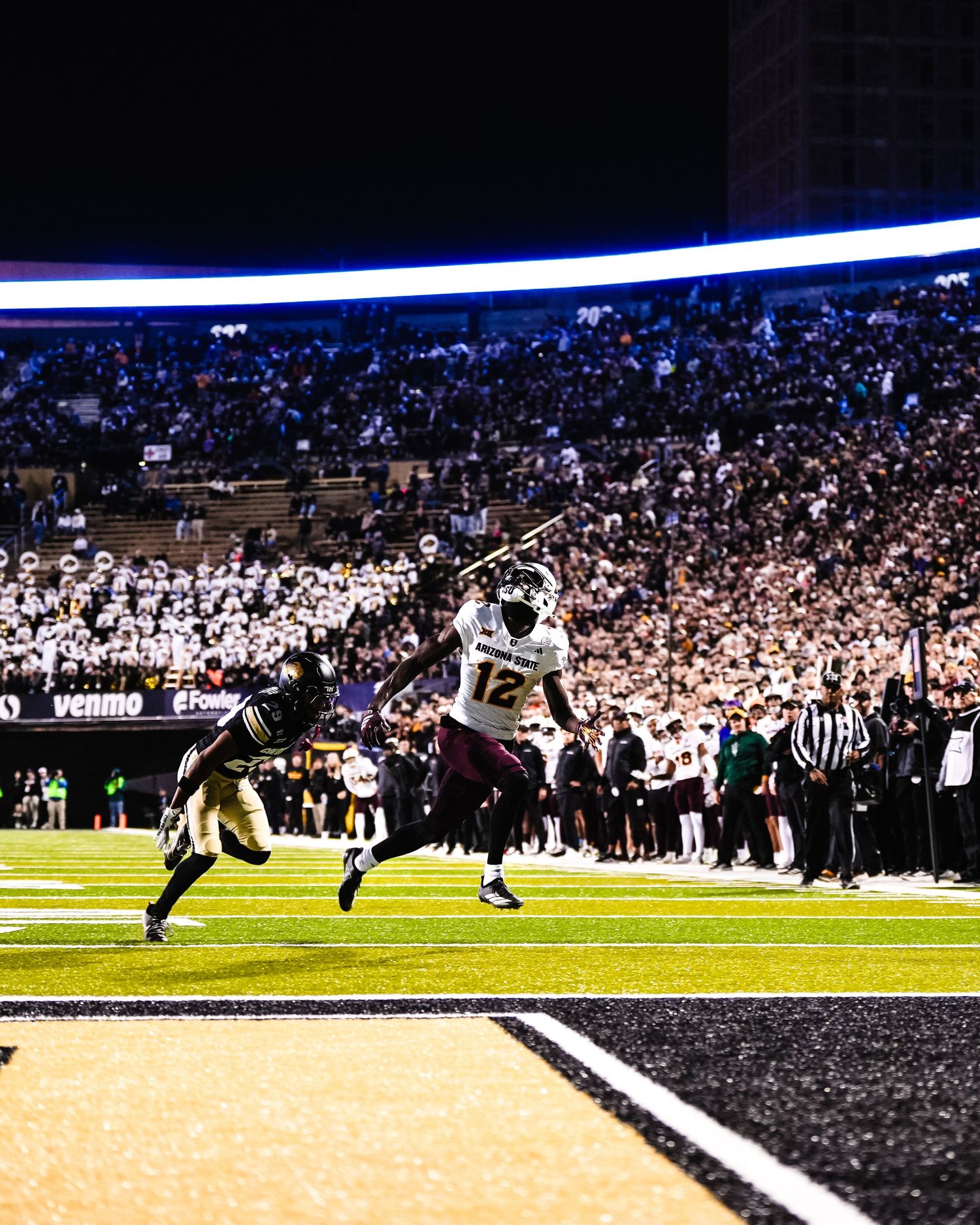 Football player looks up at the ball.