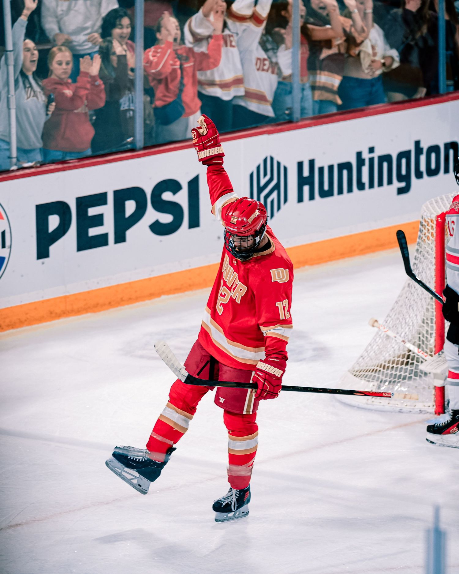 Hockey player in red uniform celebrates a goal.