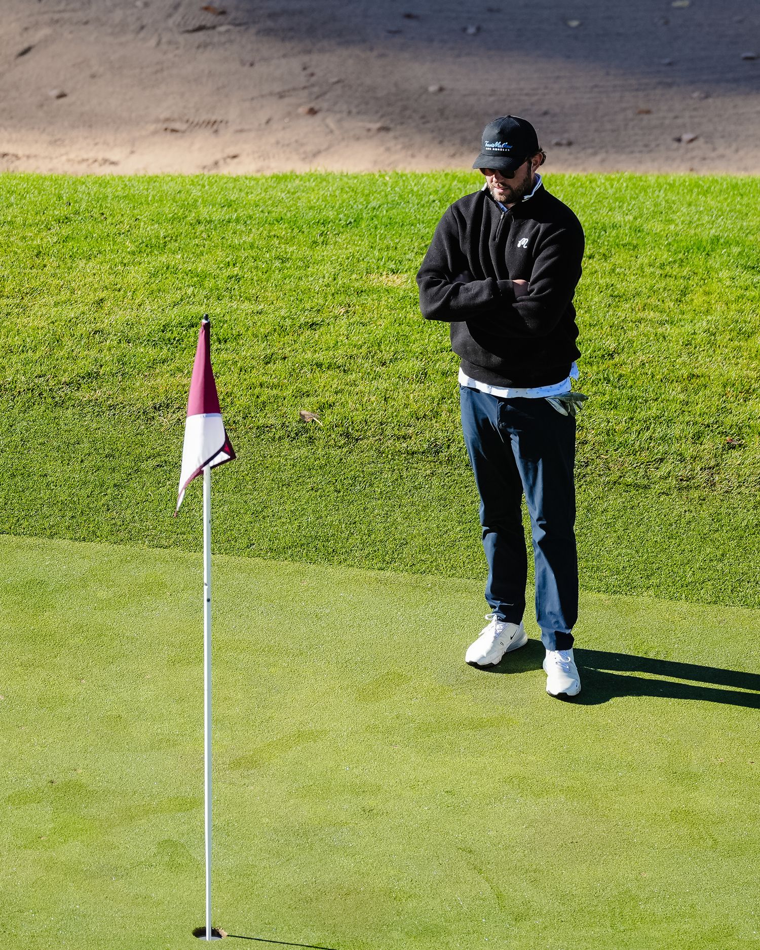 Golfer practicing putting on a green course.