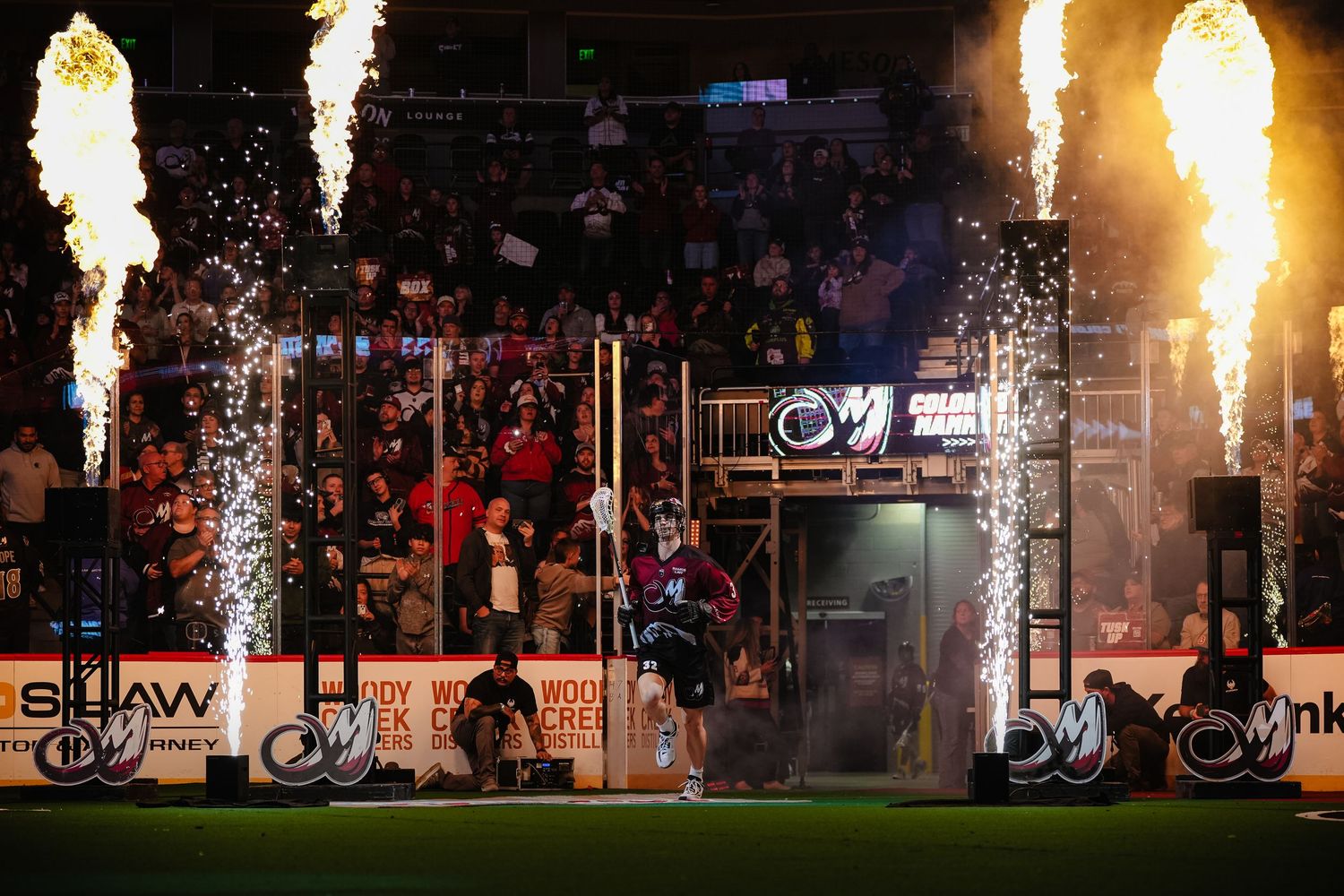 Dramatic pyrotechnic display with fire effects during indoor sports event.