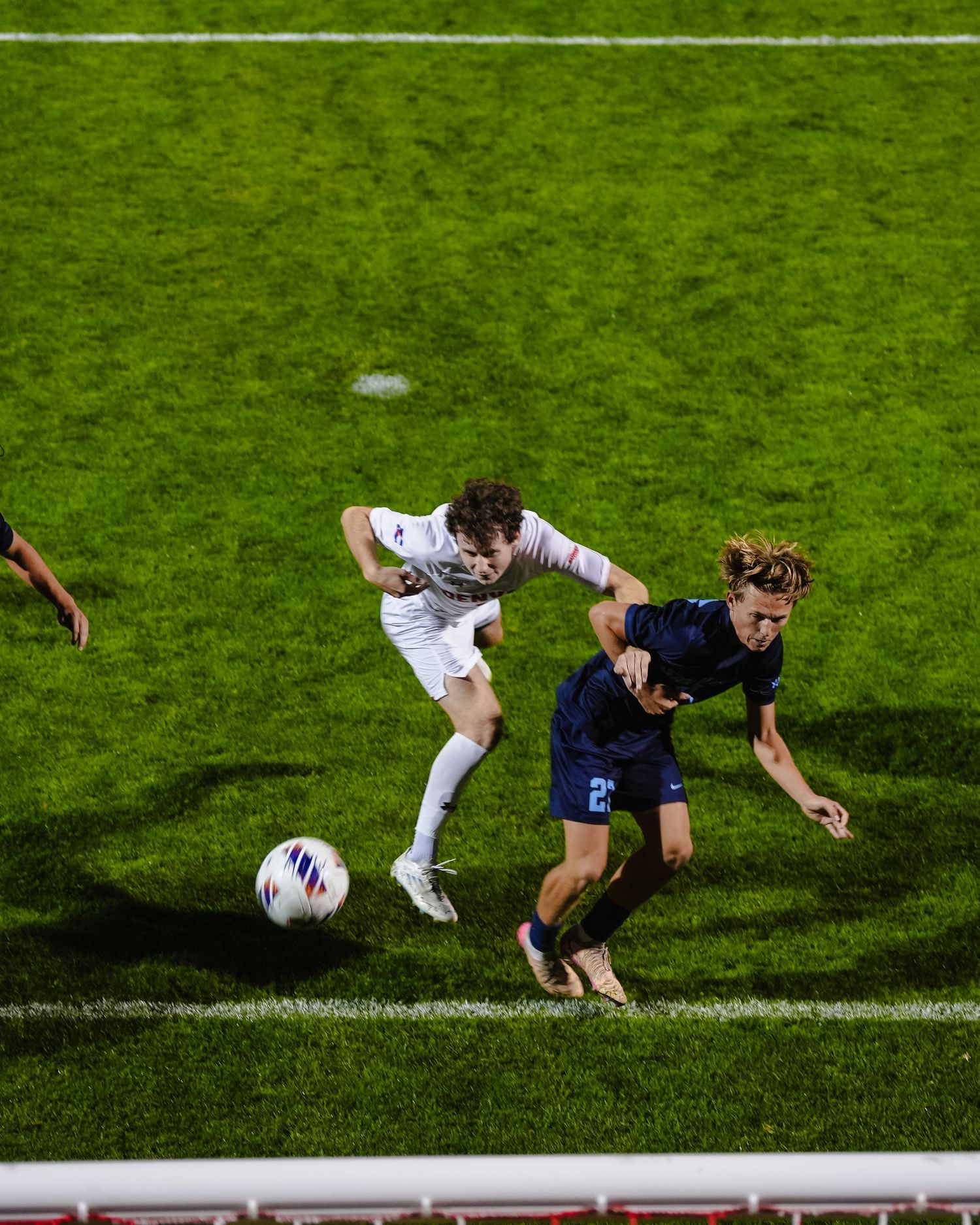 Soccer players heads a ball into the net.