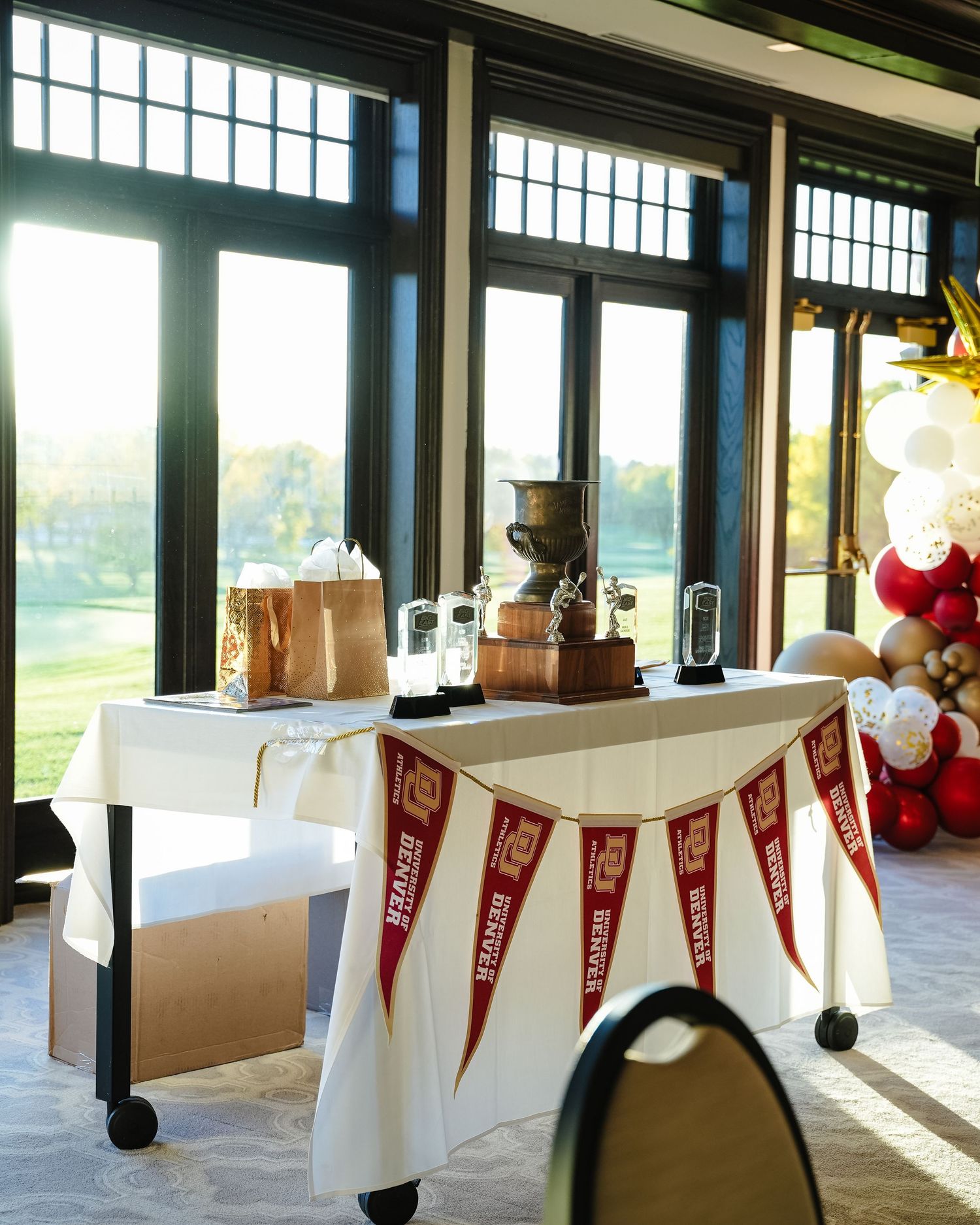Indoor venue decorated with red and white pennant banners along tables.