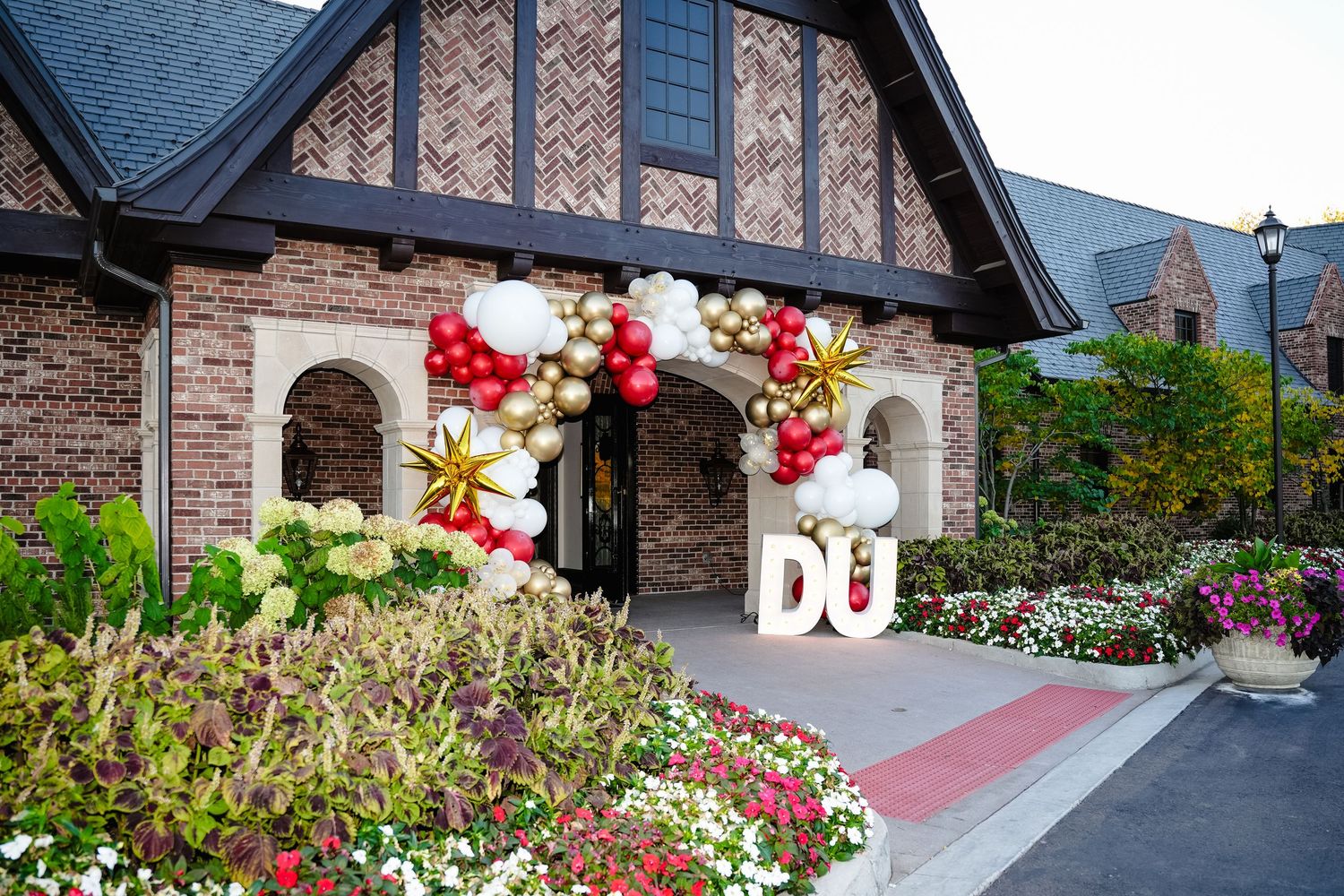 Building exterior decorated with colorful floral arrangements and balloons.