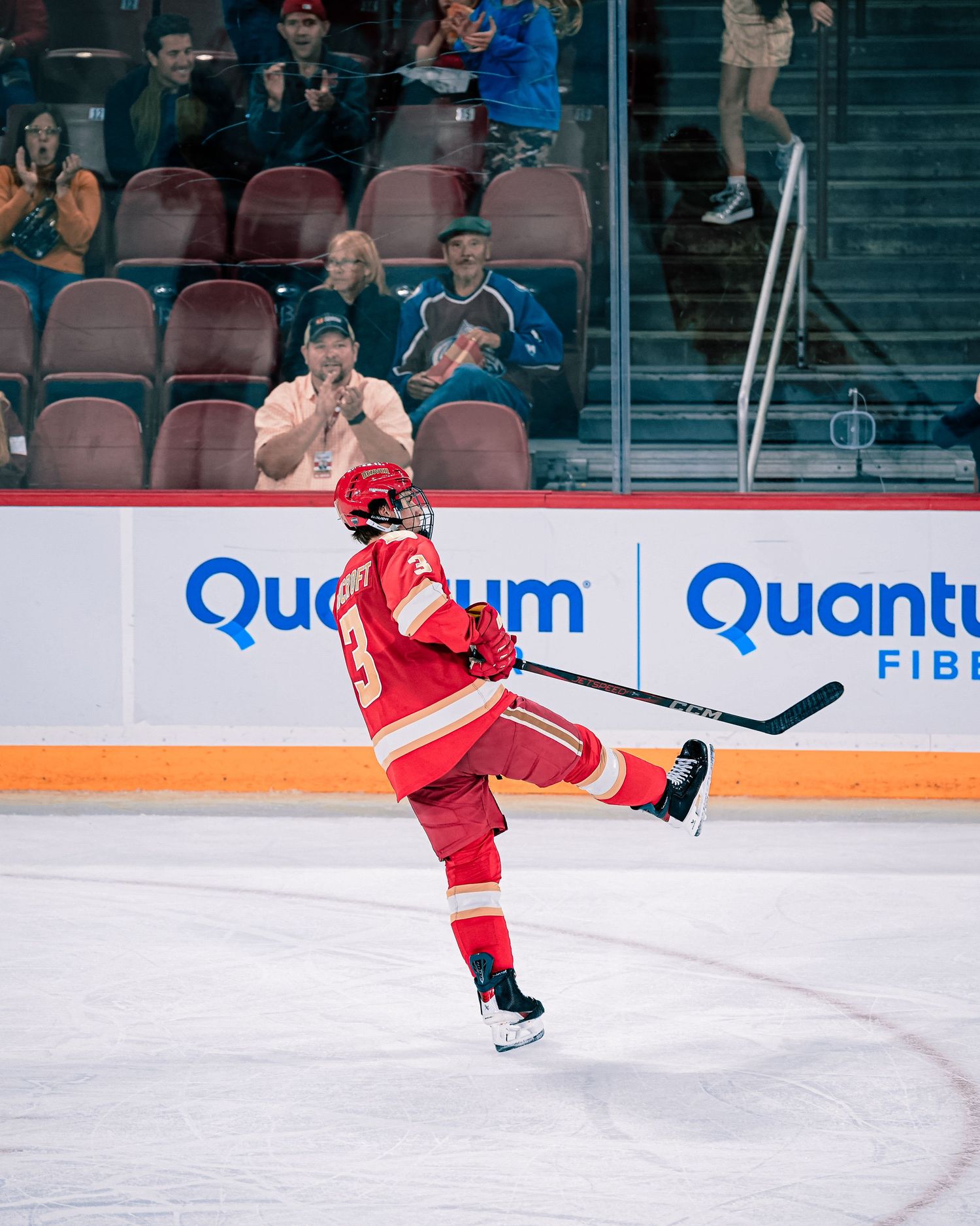 A hockey player in red uniform celebrates a goal.