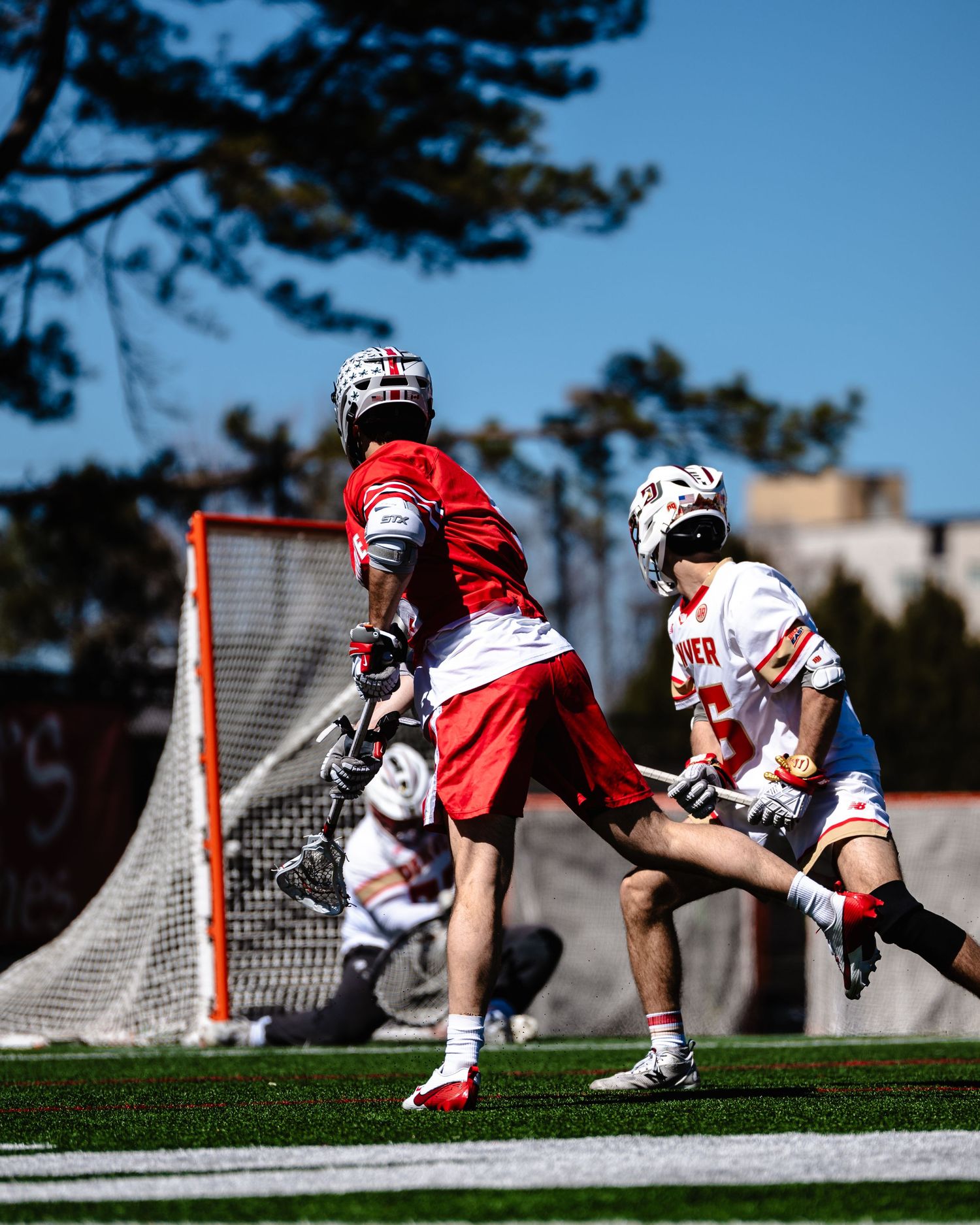 Lacrosse player scores a goal.