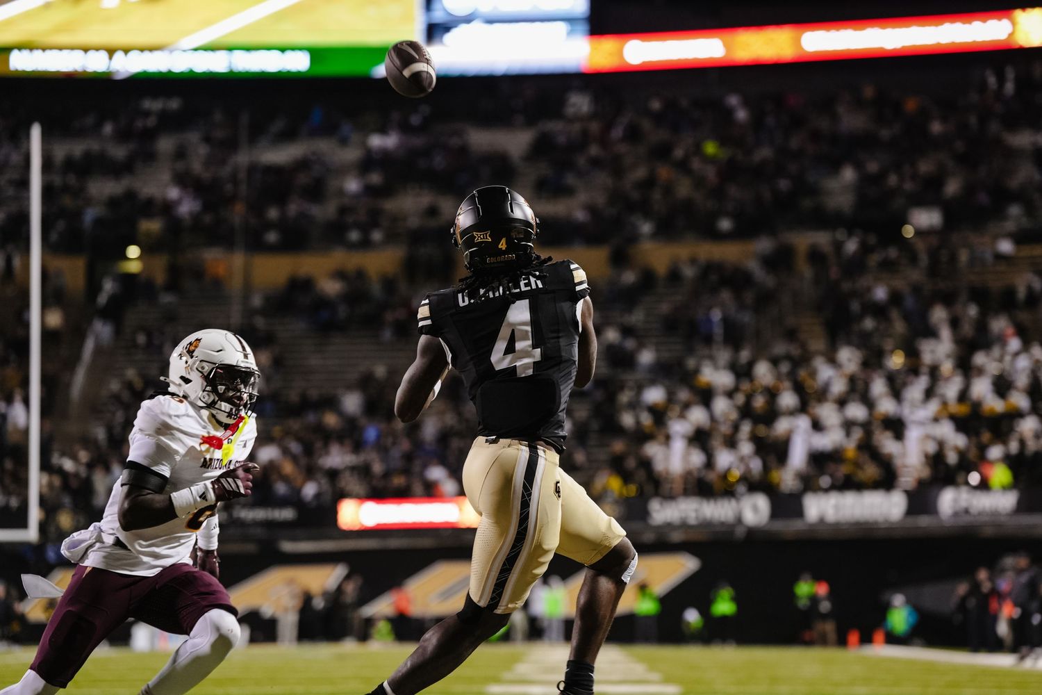 Football player is about to catch the ball.