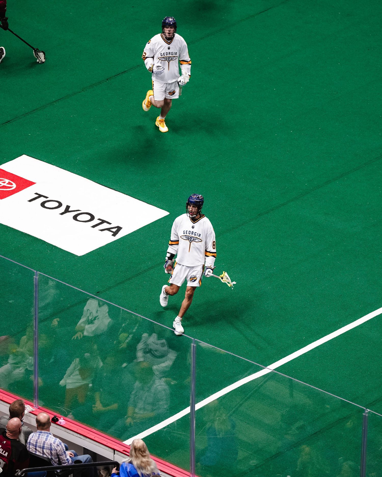Indoor lacrosse player celebrating.