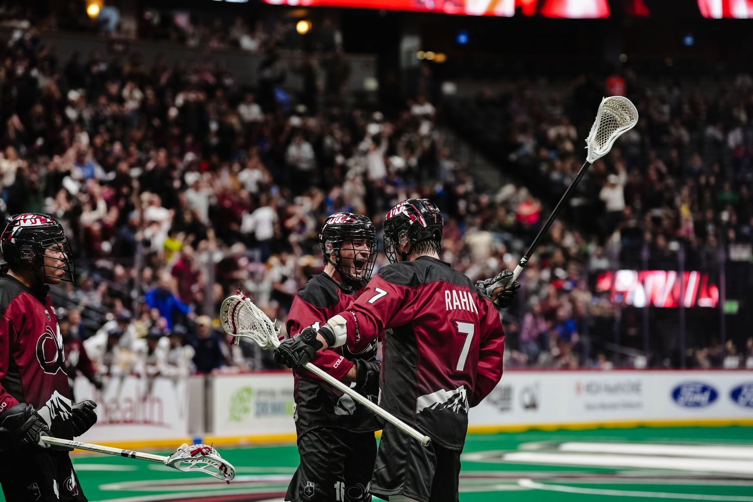 Lacrosse players celebrate a goal.
