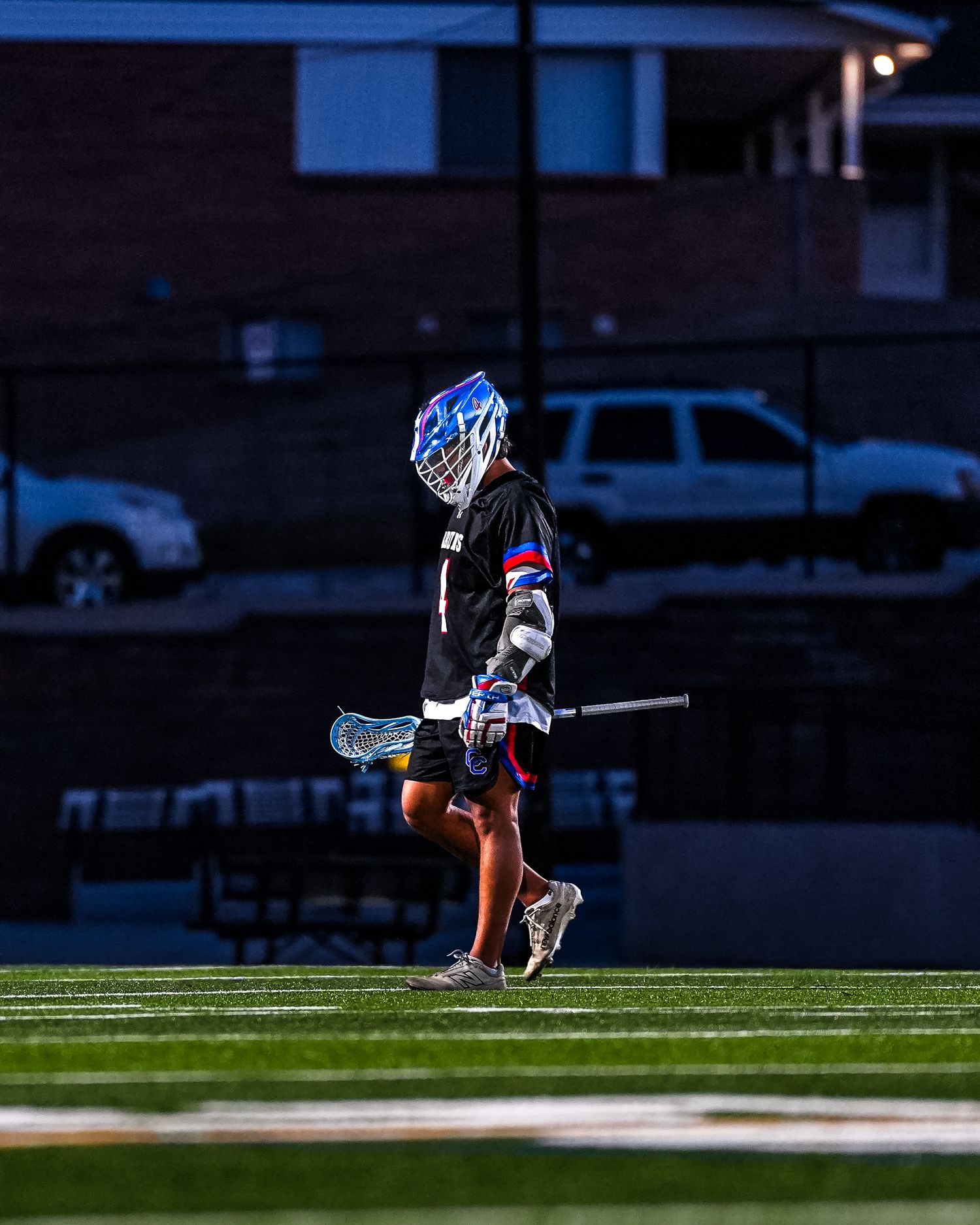 Lacrosse player in dramatic lighting.