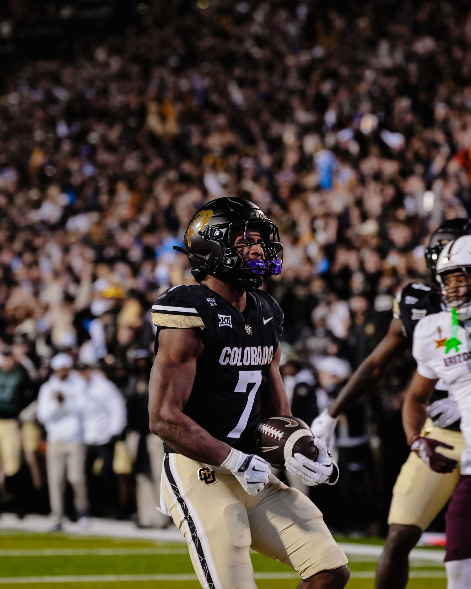 Colorado football player in black and gold uniform celebrates.