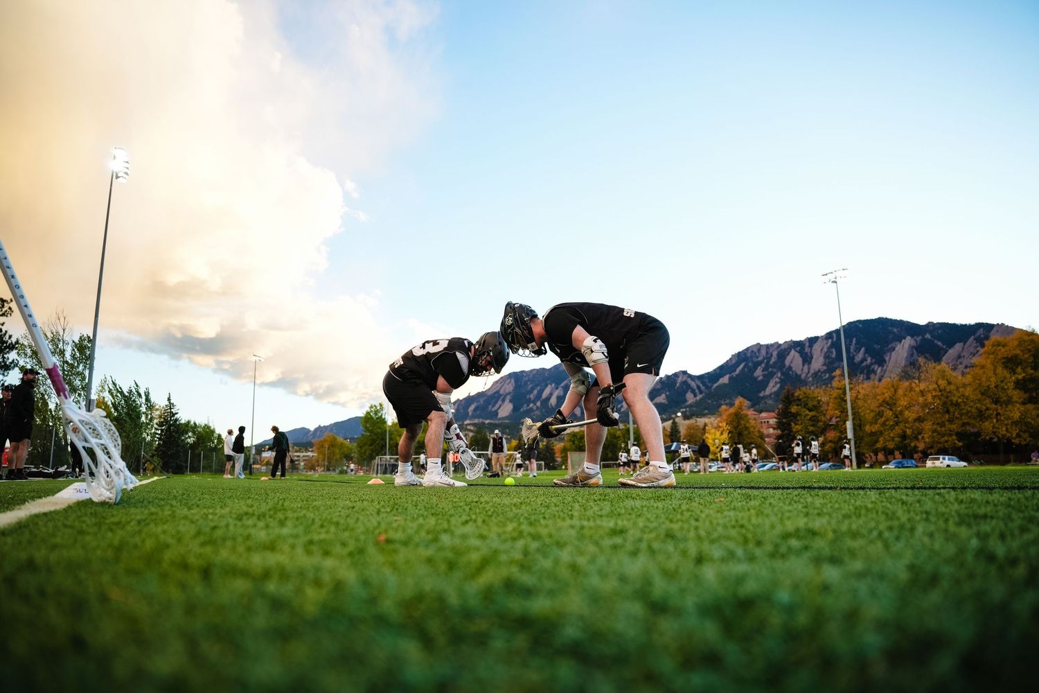 Lacrosse players practice faceoffs.