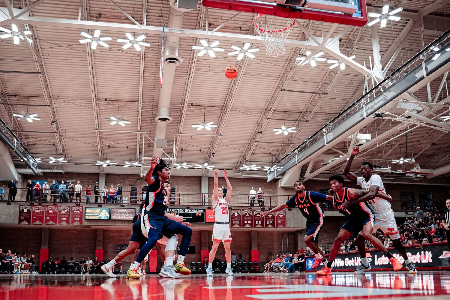 Basketball players compete in an indoor gymnasium.