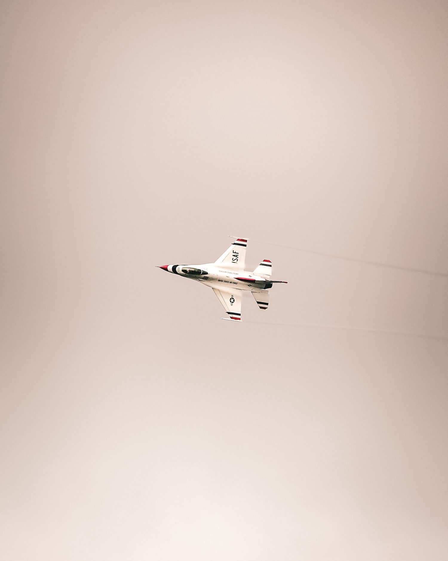 Small aircraft flying against a light beige sky background.