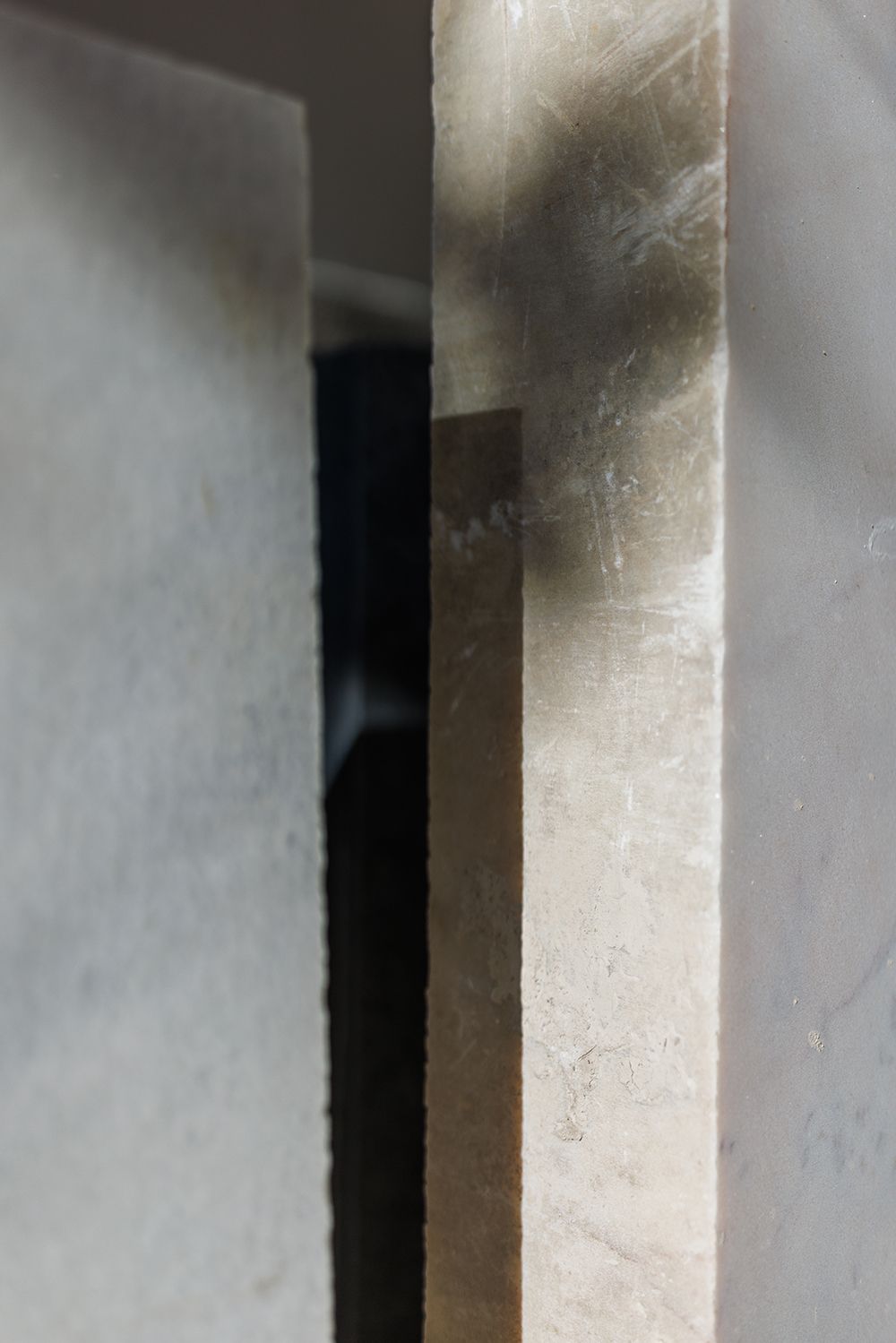 Close-up abstract detail of smooth marble stone slabs with light and shadow contrasts.
