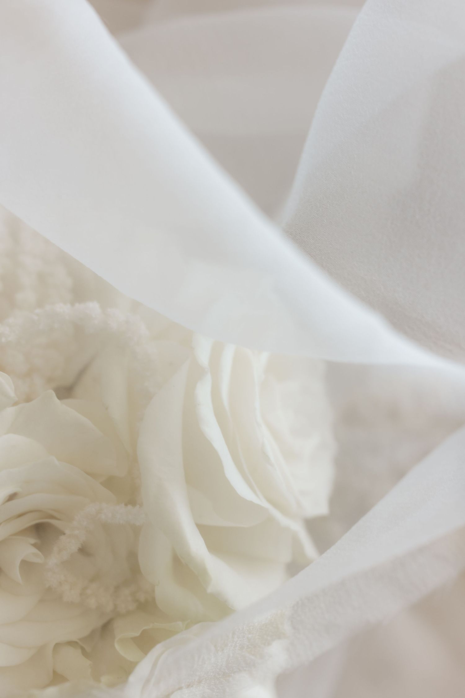 White roses and textured ivory beaded necklace wrapped in soft white bridal veil tulle fabric.
