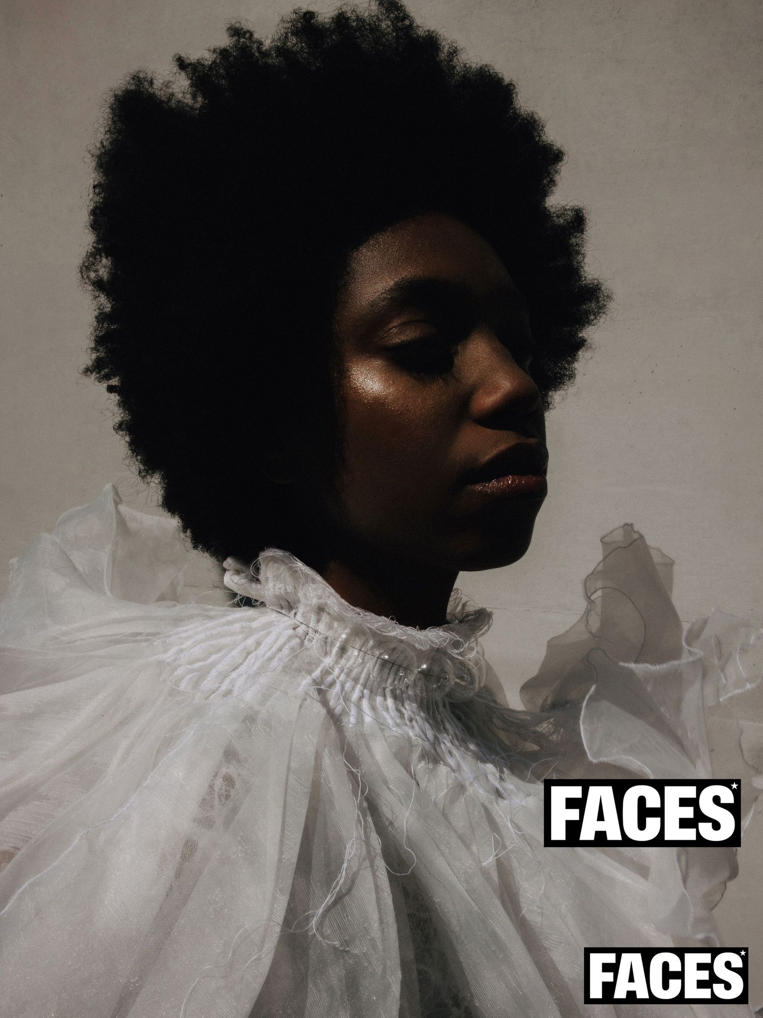 Close-up portrait of a woman with an afro wearing a white ruffled top, labeled FACES.