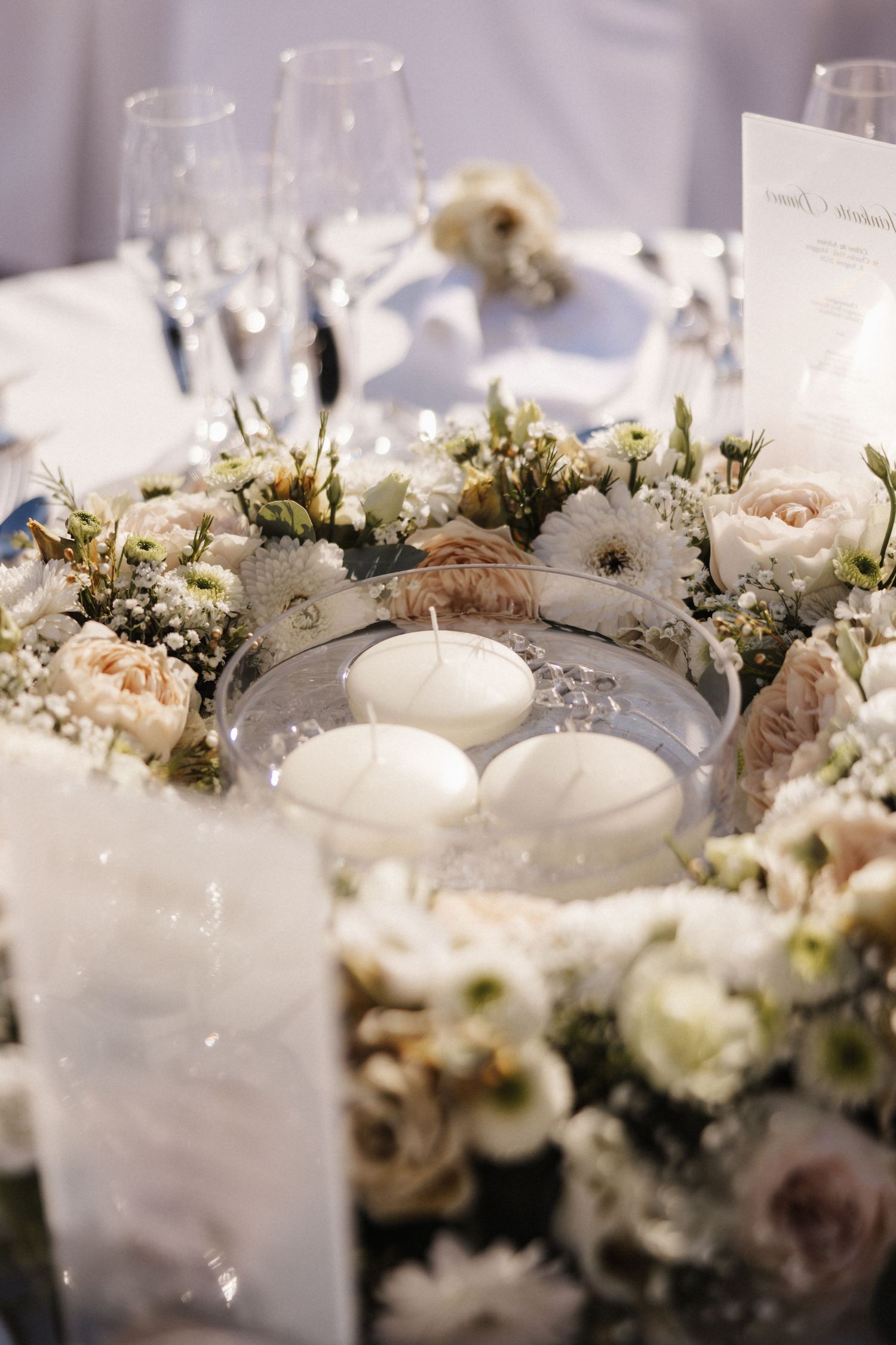 Romantic wedding centerpiece with floating white candles surrounded by blush and white floral wreath.
