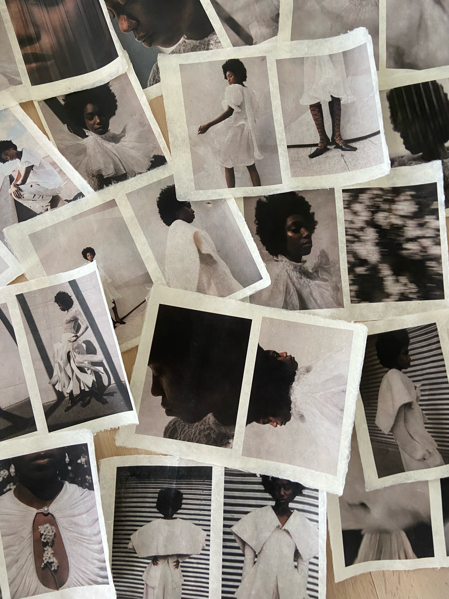 Collection of vintage Polaroid photos scattered on wood surface showing Black woman in white dress editorial.