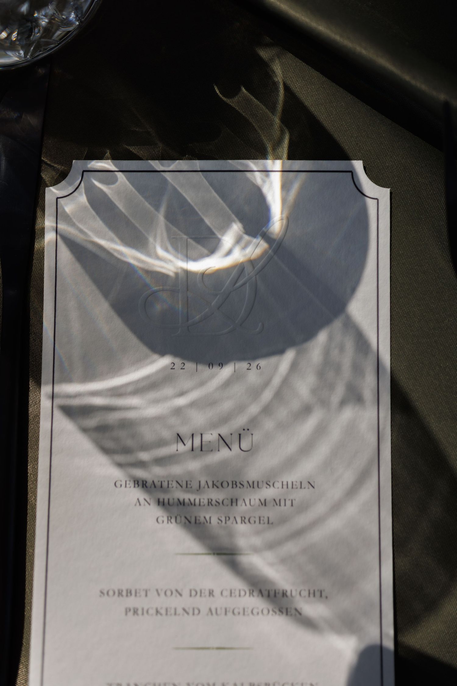 Elegant German wedding menu card dated 22.09.24 with shadow overlay on dark table.