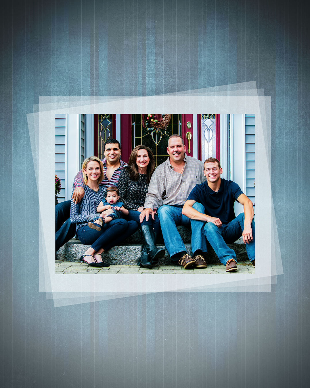 A family of seven poses together on front porch steps in a framed photo.