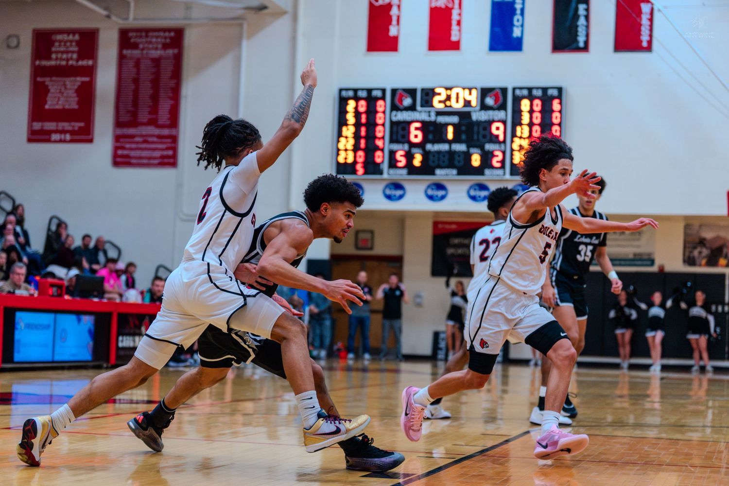 High school basketball players sprint down court during intense game action.