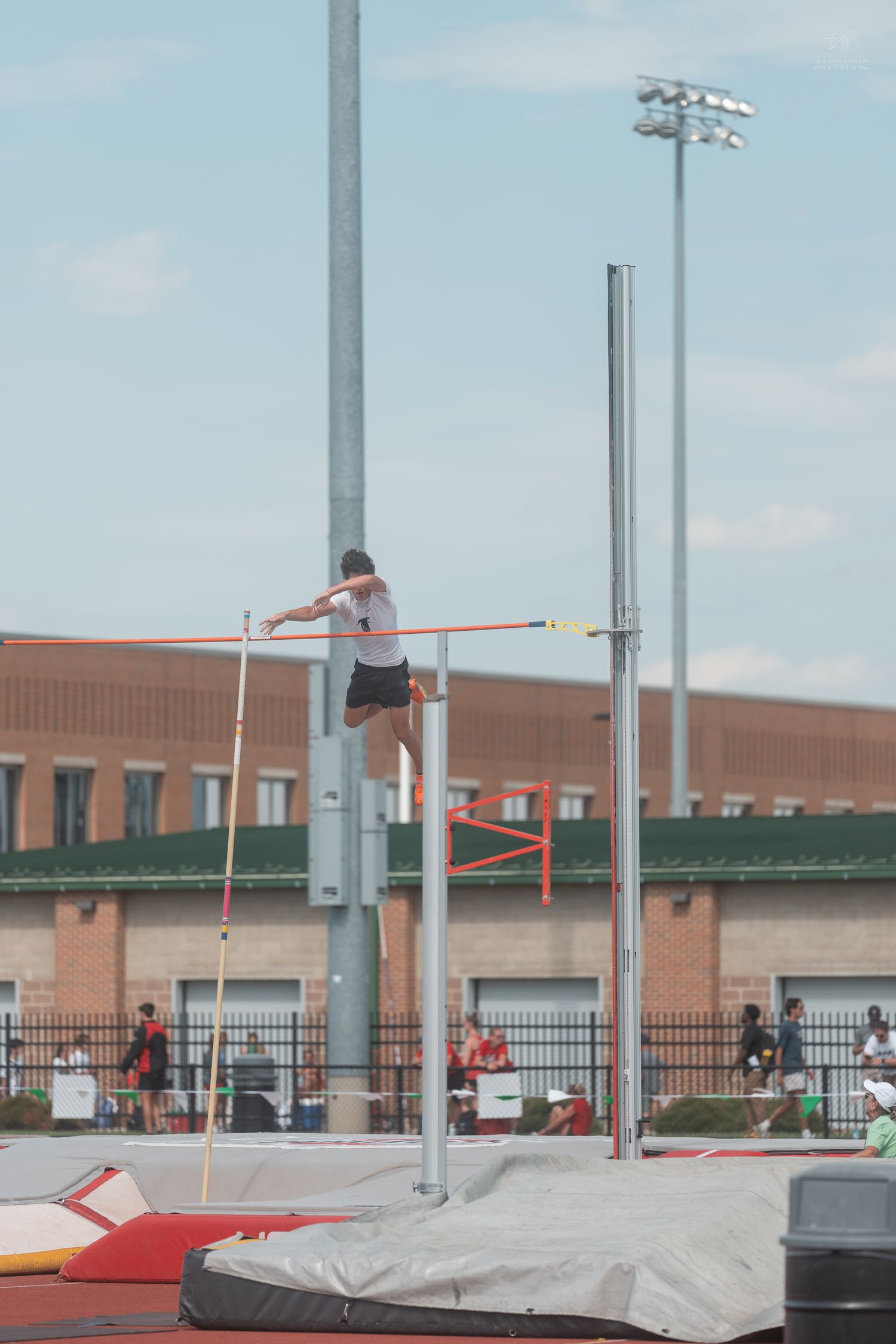 Athlete clears the pole vault bar at an outdoor Ohio State University track and field event.