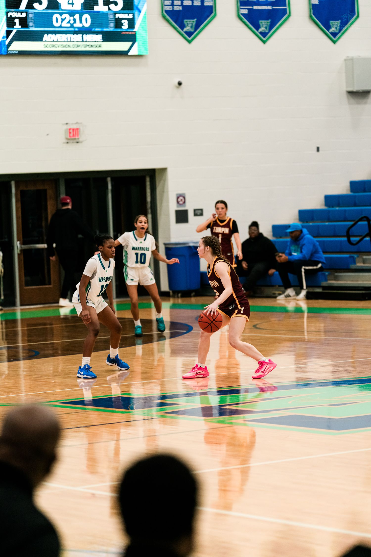 Turpin player dribbles against Warriors #10 defense during girls high school basketball.