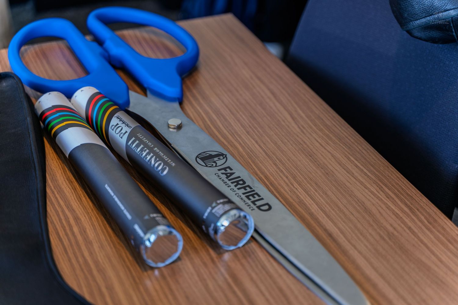 Fairfield branded scissors and markers on a wooden desk surface.