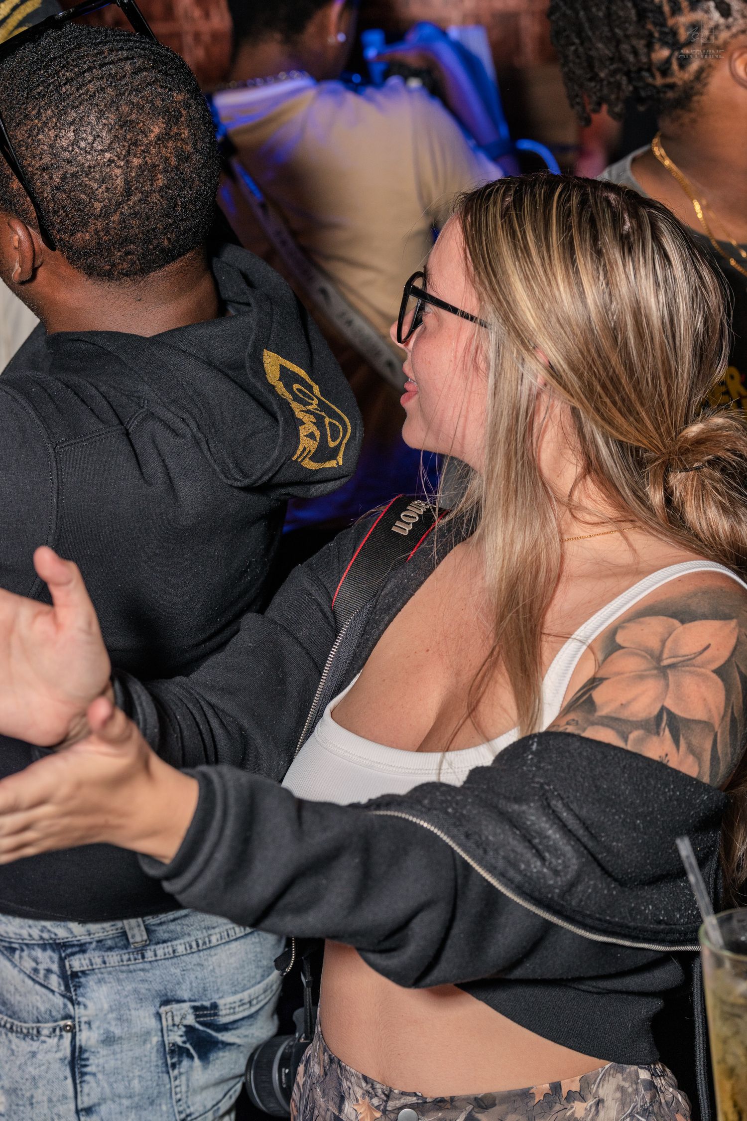 Couple dancing closely together at a crowded nightclub party event.