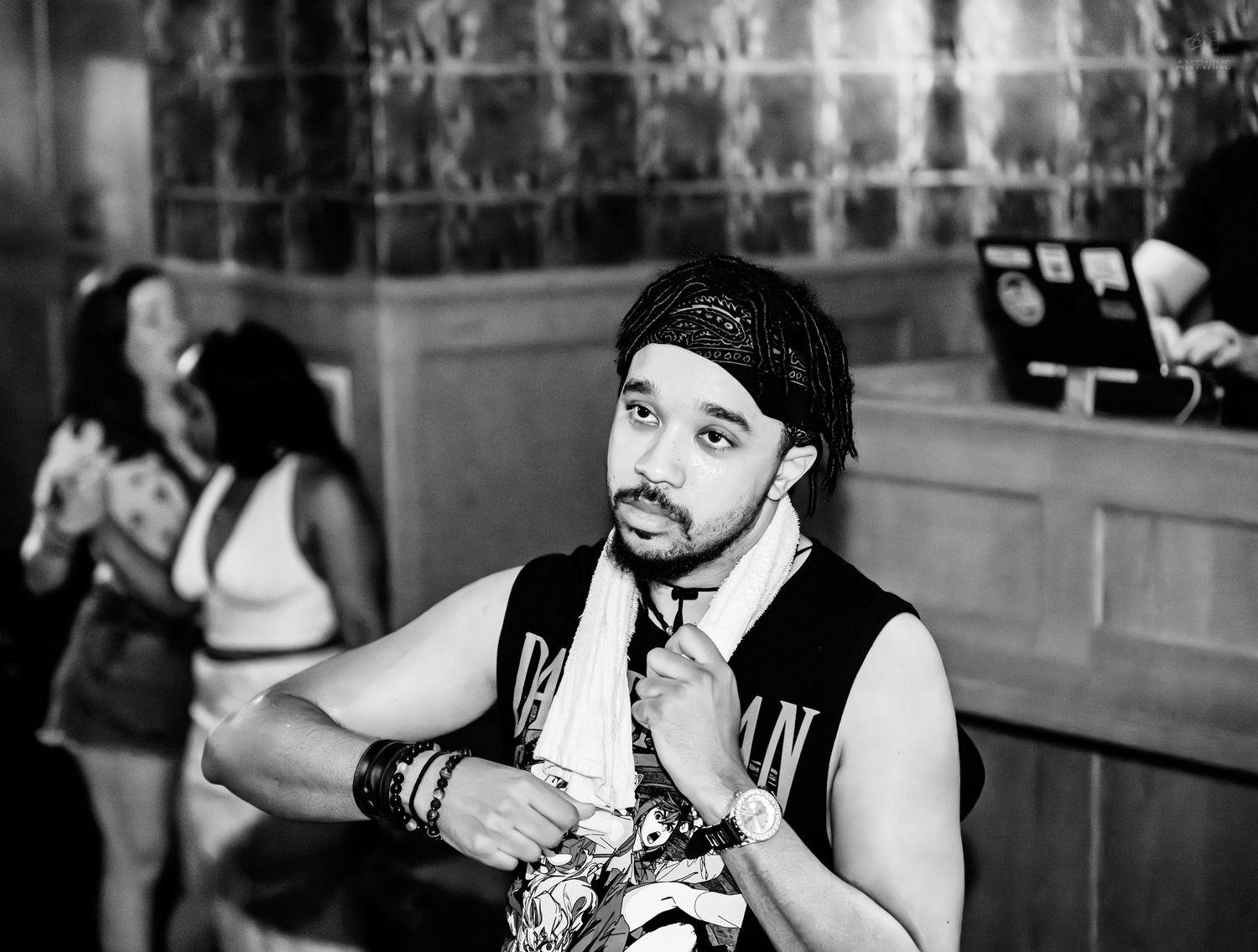 Black and white portrait of a man with bandana at a nightclub.