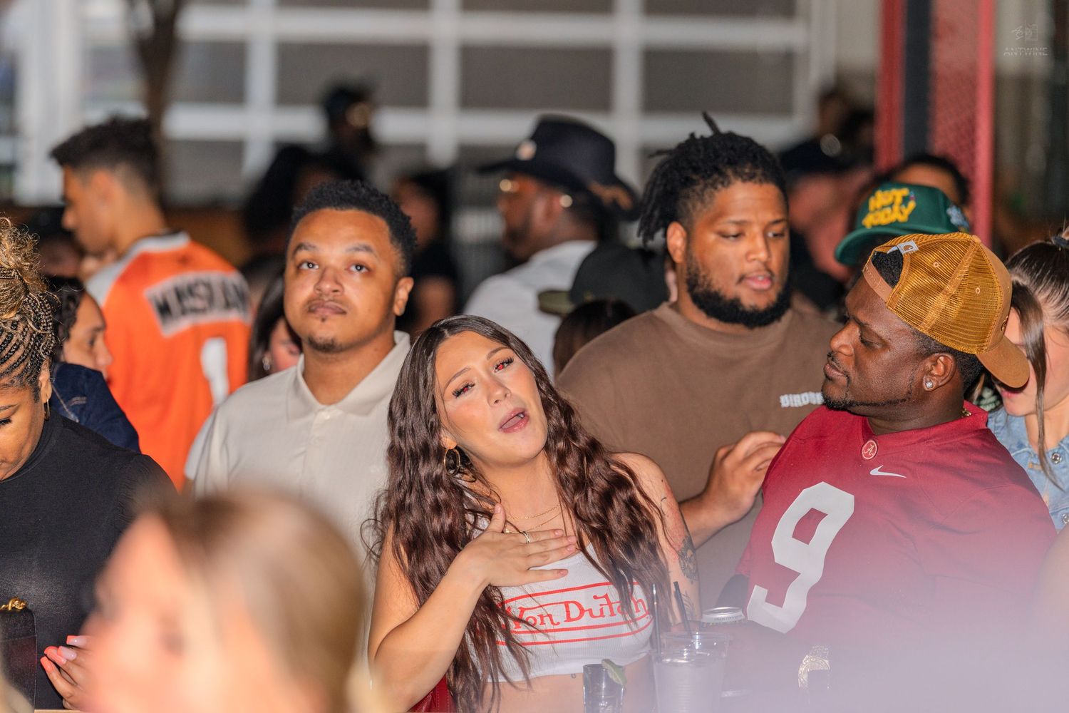 A diverse crowd of young people socializing outdoors at a busy nighttime event.
