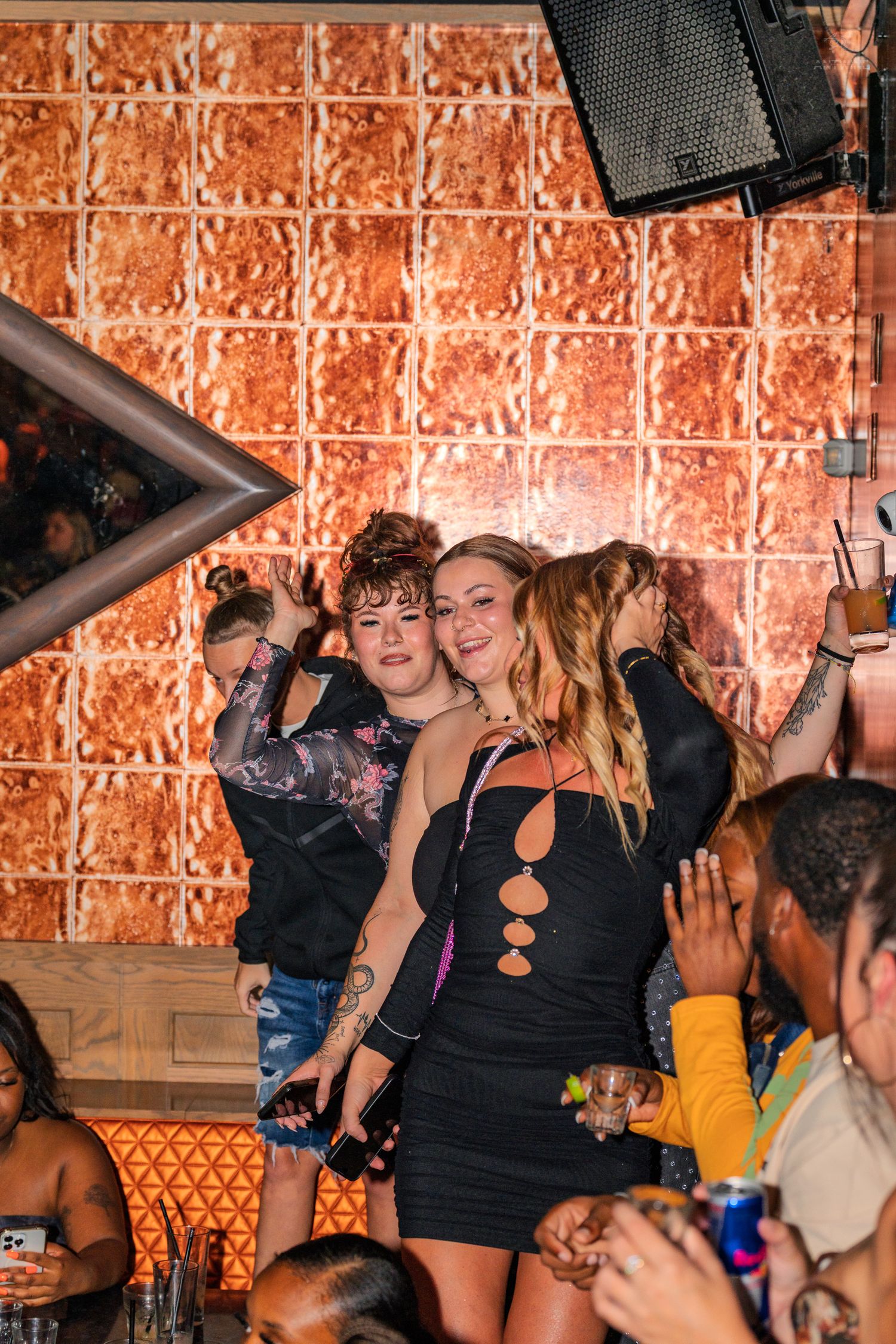 Two women posing and dancing together at vibrant nightclub party event.