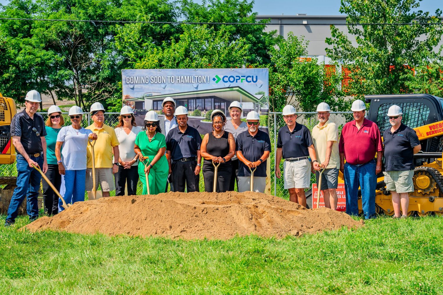 Group of people in hard hats standing with shovels at COPFCU groundbreaking ceremony.