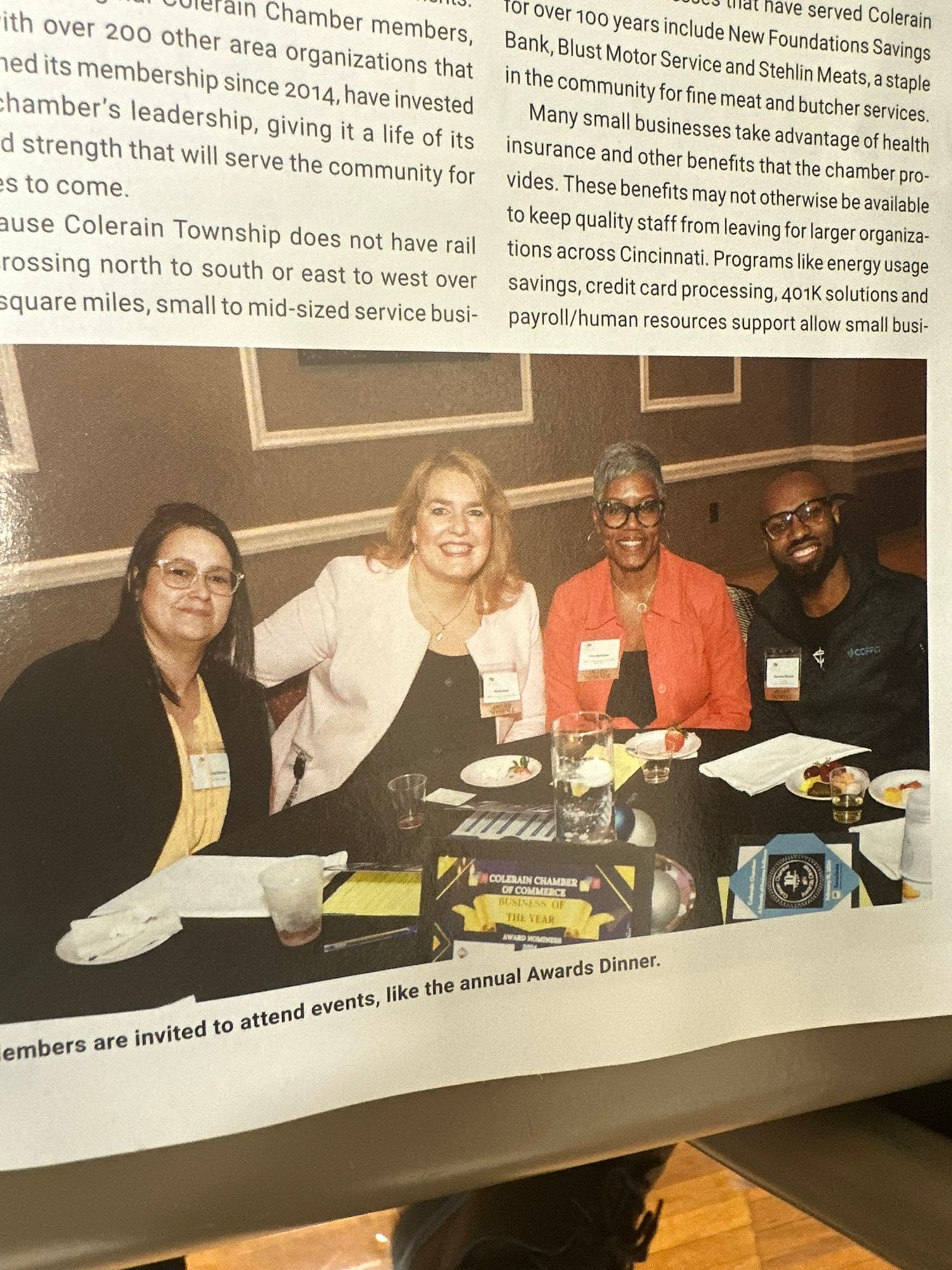 Four professionals pose together smiling at a chamber of commerce awards dinner networking event.