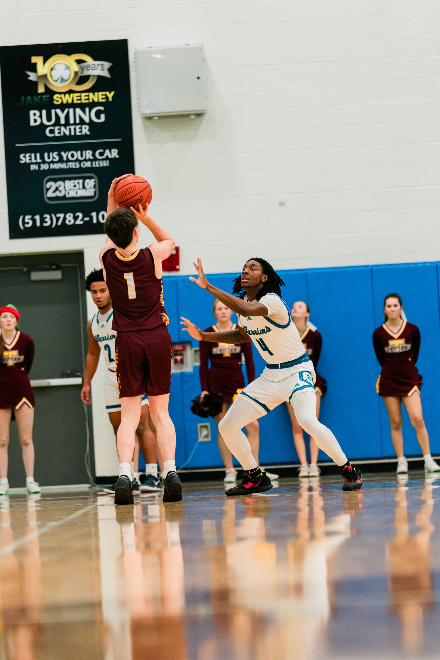 Turpin player #1 shoots over a Winton Woods Warriors defender during a high school basketball game.