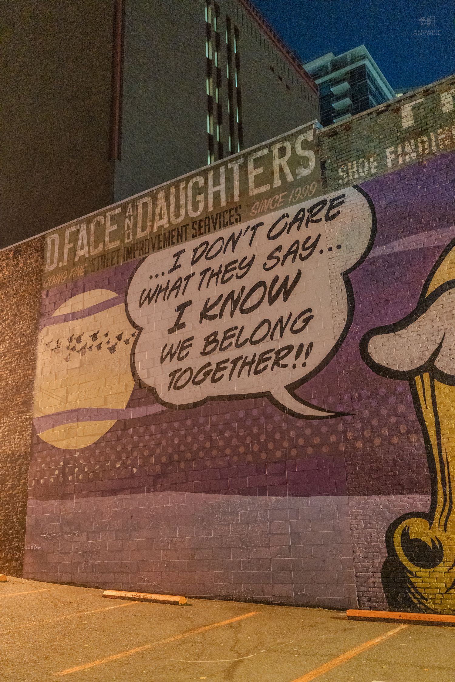 Colorful comic-style mural by D.Face and Daughters reading I Don't Care What They Say I Know We Belong Together.