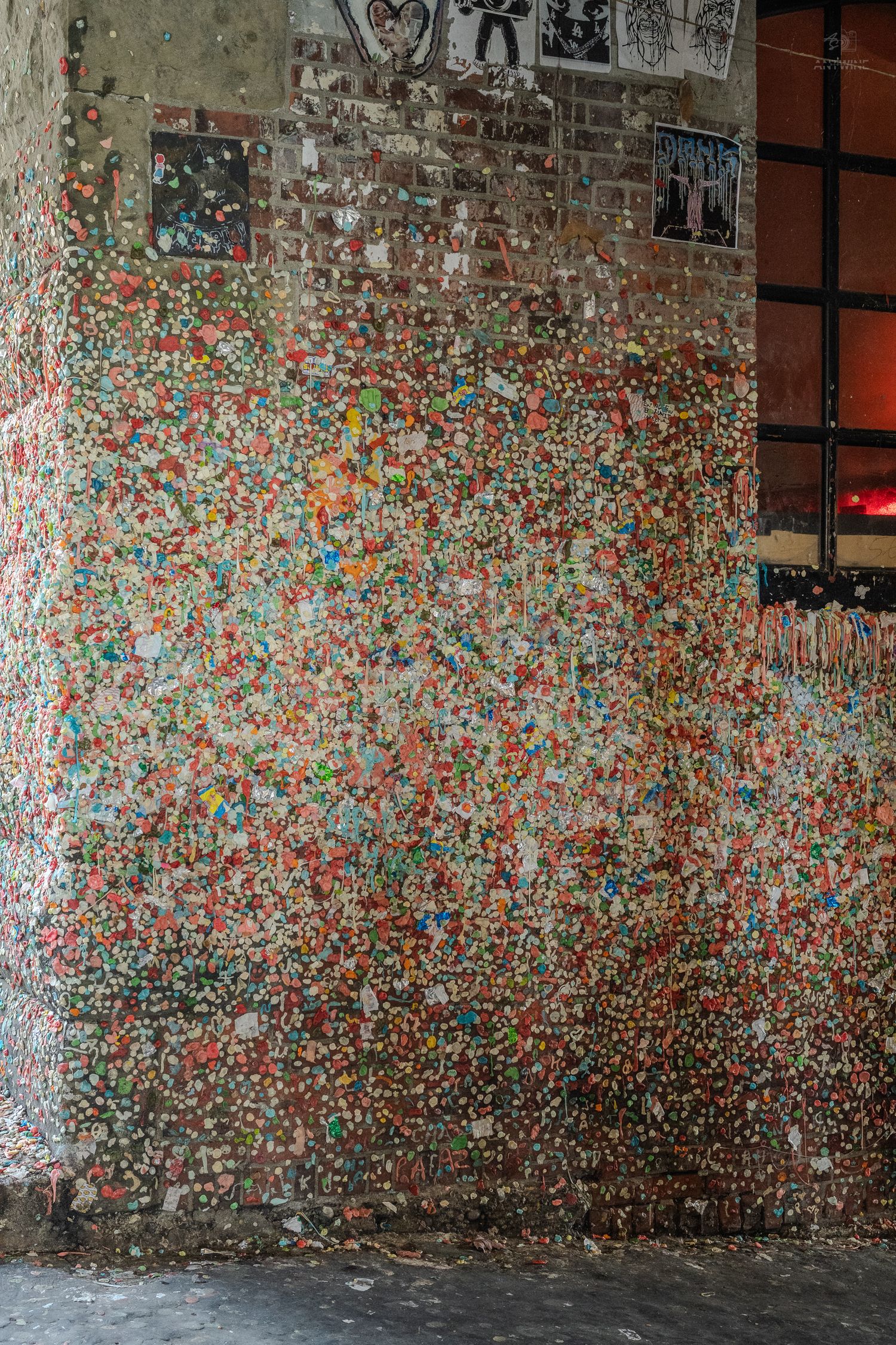 Colorful chewing gum wall covered in layers of multicolored gum pieces, a famous tourist attraction in Seattle.