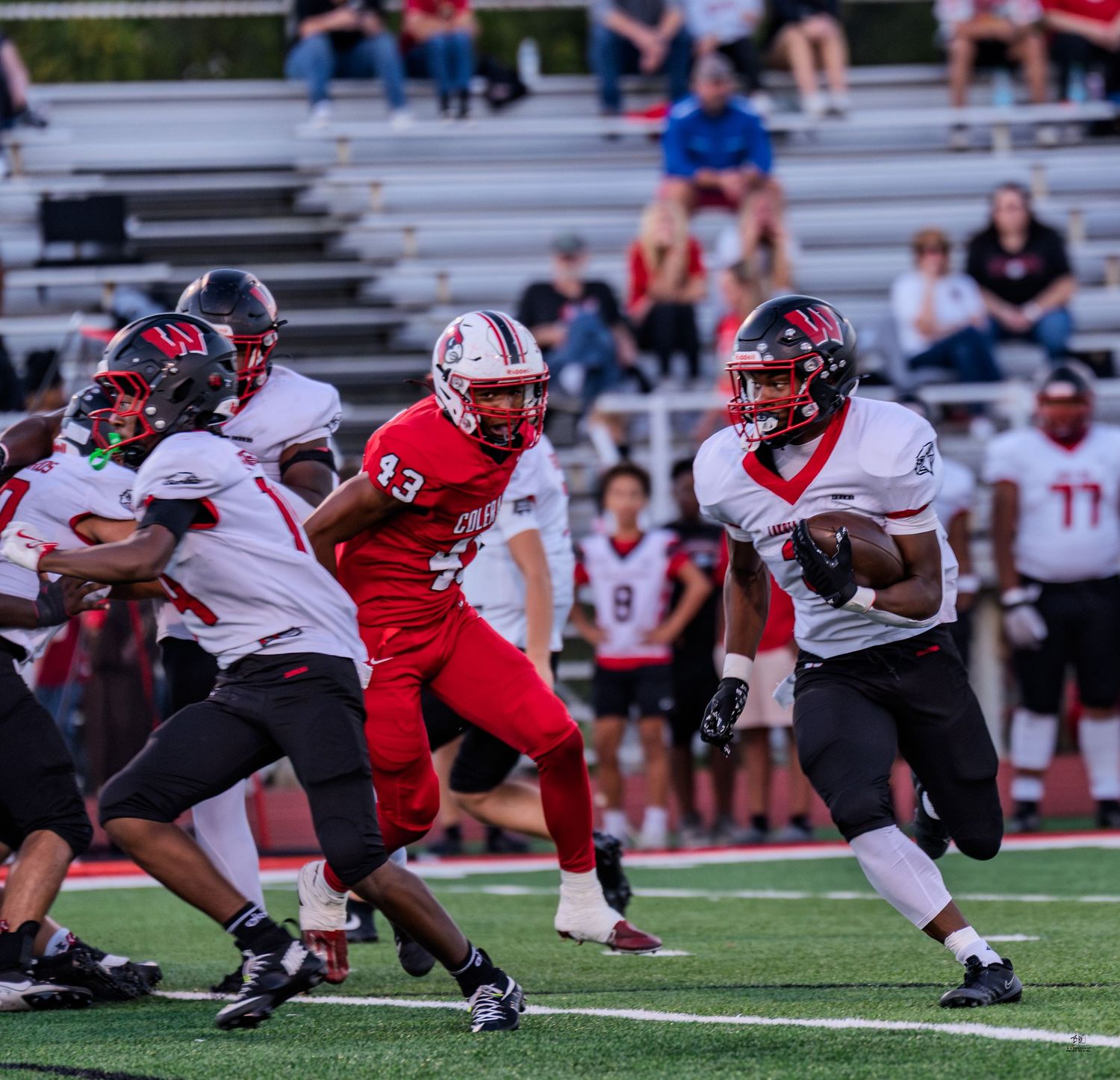 Running back in dark uniform breaks past Colerain defender number 43 during high school football game.